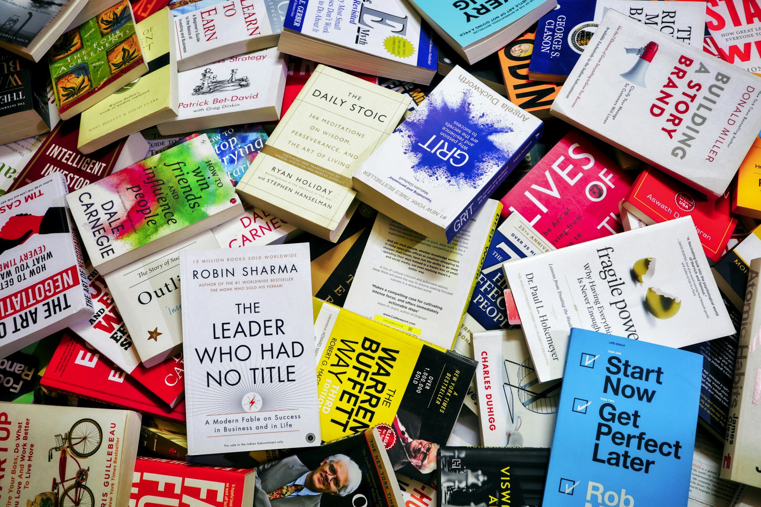 A collection of various books piled together, featuring titles on business, self-help, philosophy, and success.