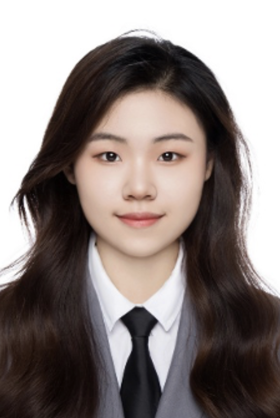 Young woman with long dark hair, wearing a white shirt, black tie, and gray blazer, smiling against a white background.