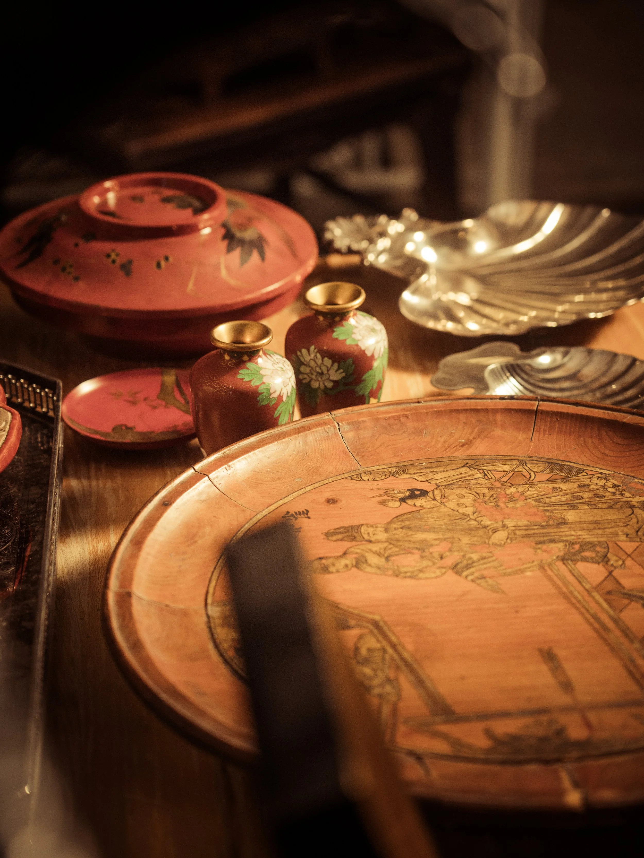 Two beige armchairs with matching ottomans in a minimalist room with white walls and dark gray floor.