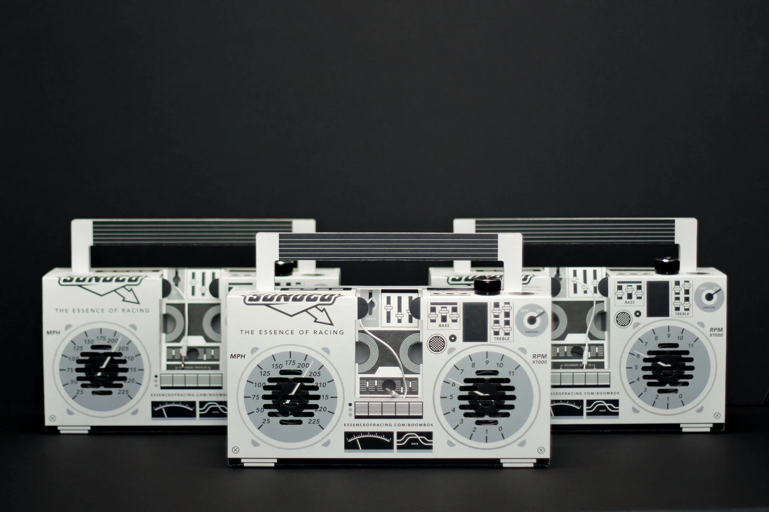 Set of three white toy boomboxes with black and gray details against a black background.