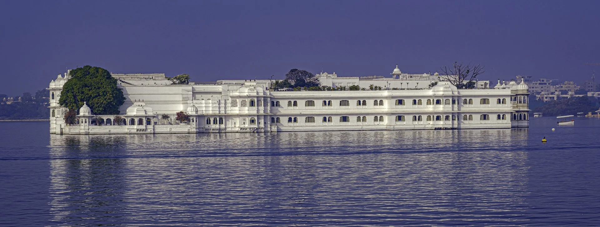 Taj Lake Palace reflected on calm water at blue hour, serene atmosphere