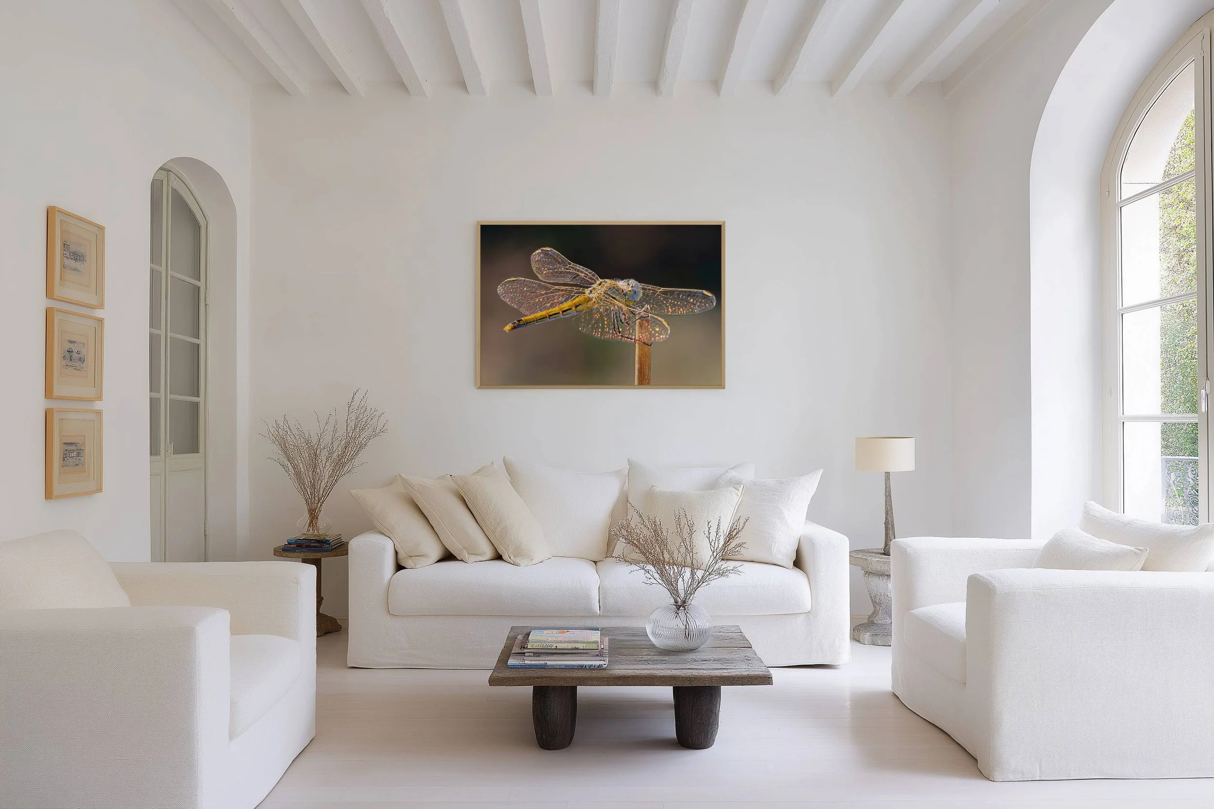 Stained Glass dragonfly Fine Art photograph displayed above a white sofa in an elegant, light-filled living room.
