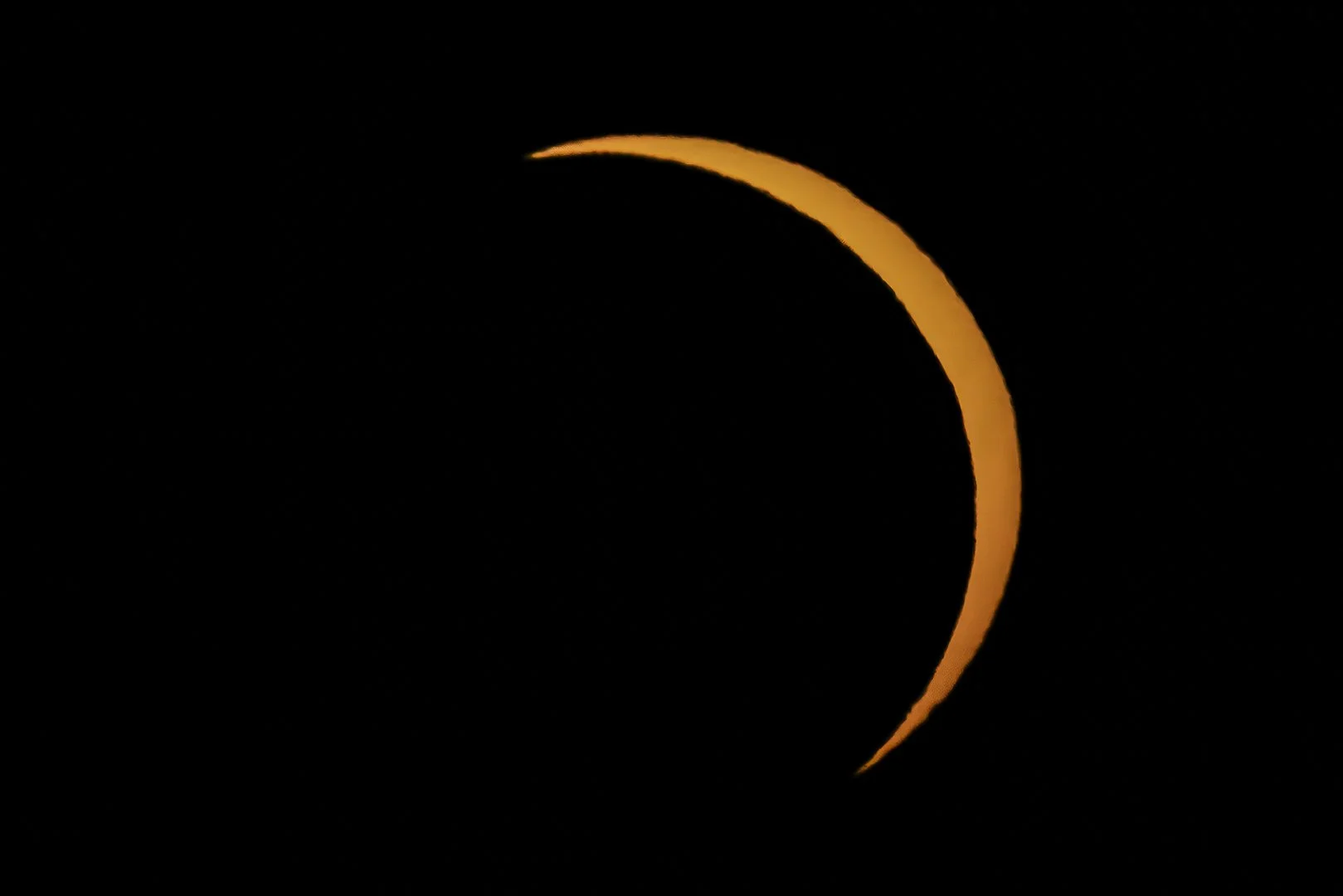 Partial solar eclipse on August 12th 2026 showing a thin crescent of sunlight against a black sky.