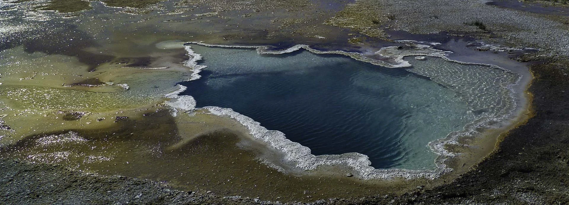 Celestine Pool hot spring in Yellowstone National Park with vivid blue water and mineral edges