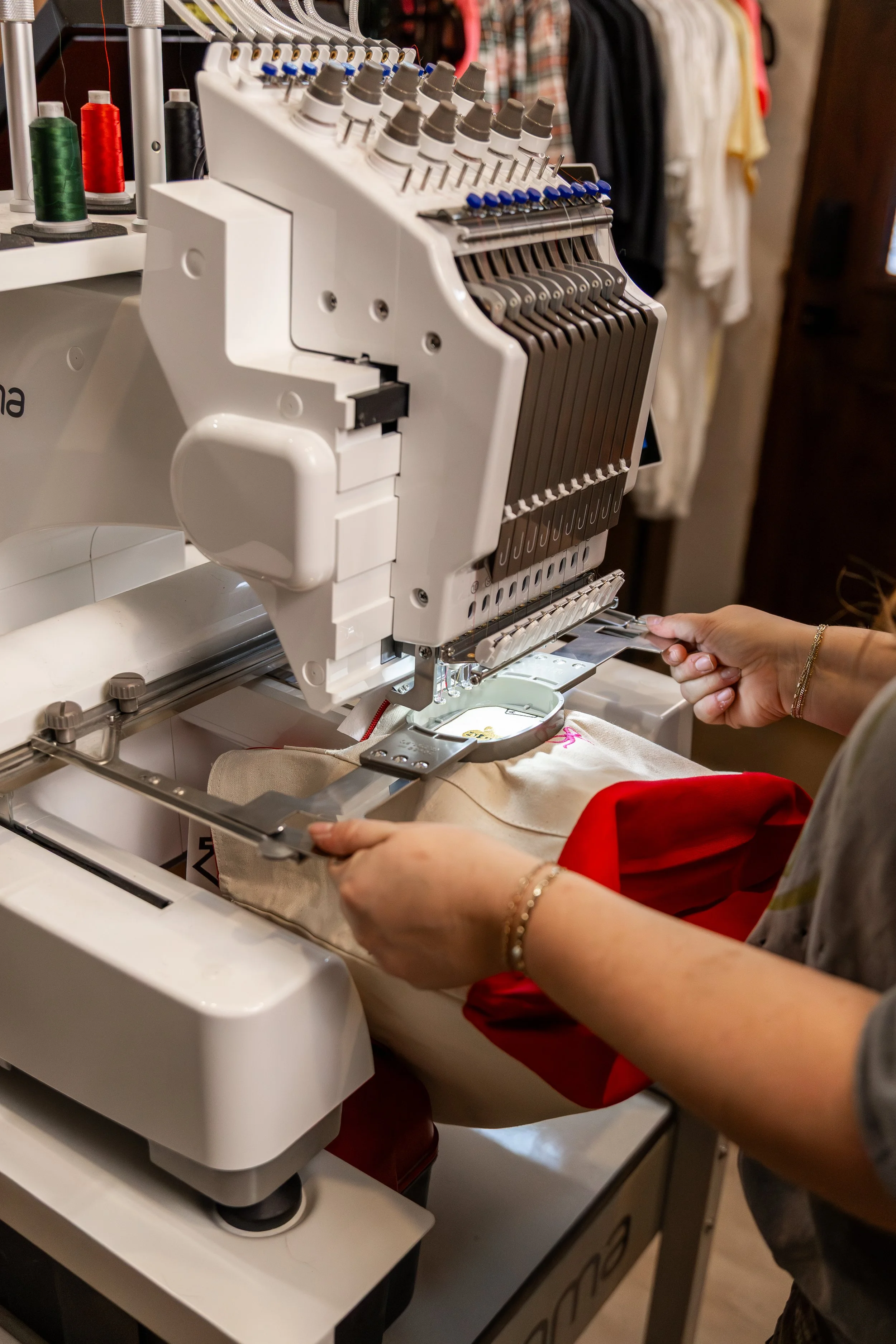 A person sewing with an embroidery machine in a craft room.