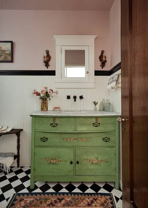 Black and white checkerboard tile floor bathroom in a Pasadena Spanish Colonial Revival home with green vintage vanity