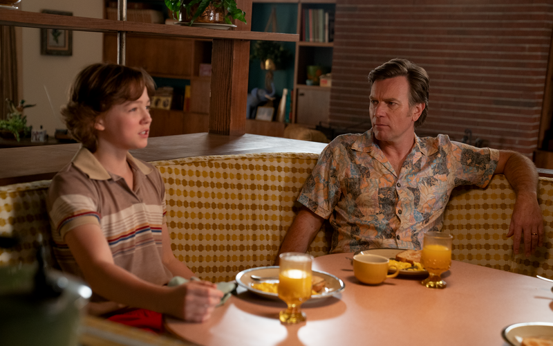 In David Robert Mitchell's 2026 film THE END OF OAK STREET, Greg (Ewan McGregor) and Brian (Christian Convery) discuss the dinosaurs in their picturesque 1982 suburban neighborhood in a sunken conversation pit in their home.
