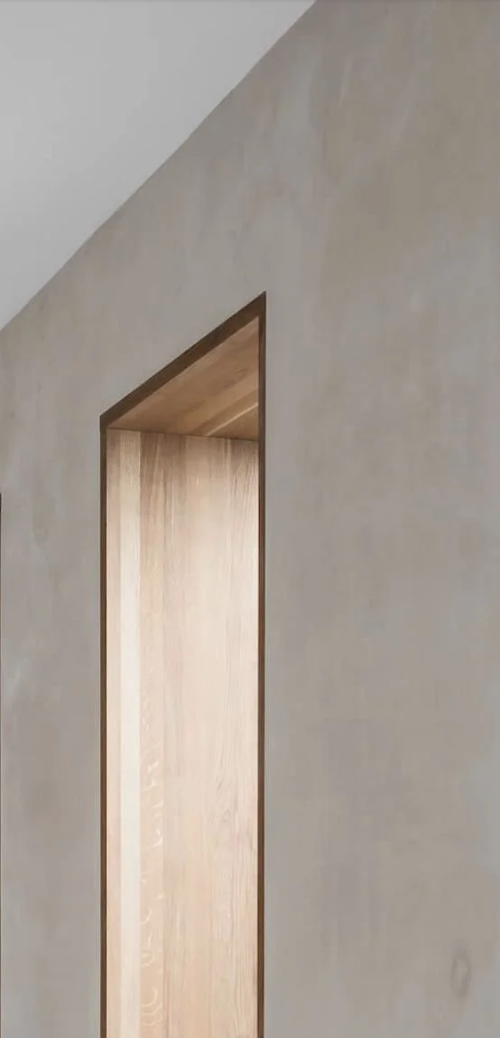 Binnenmuur met opening, houten deur of raam en een plafondhoek, minimalistisch interieur.