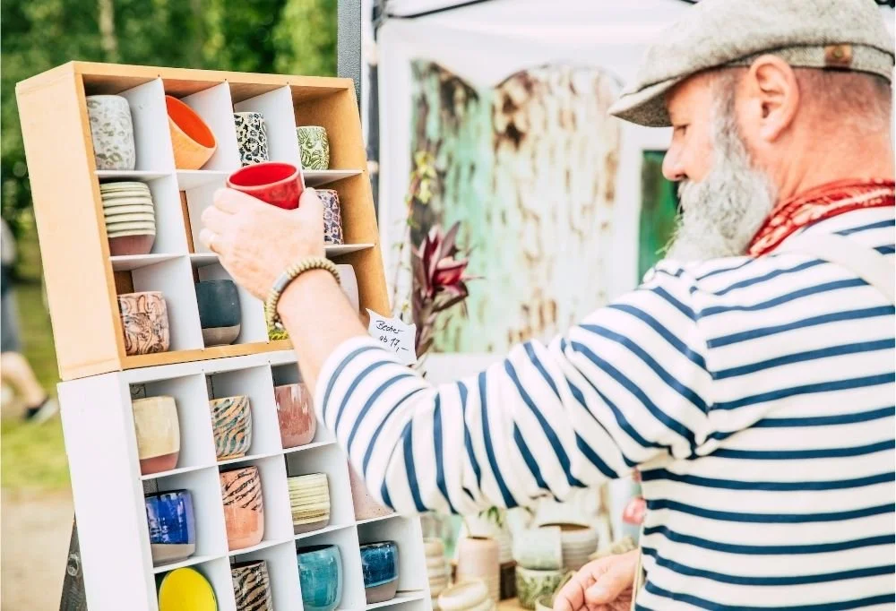 Bärtiger Mann schaut sich einen Handgemachte Becher an
