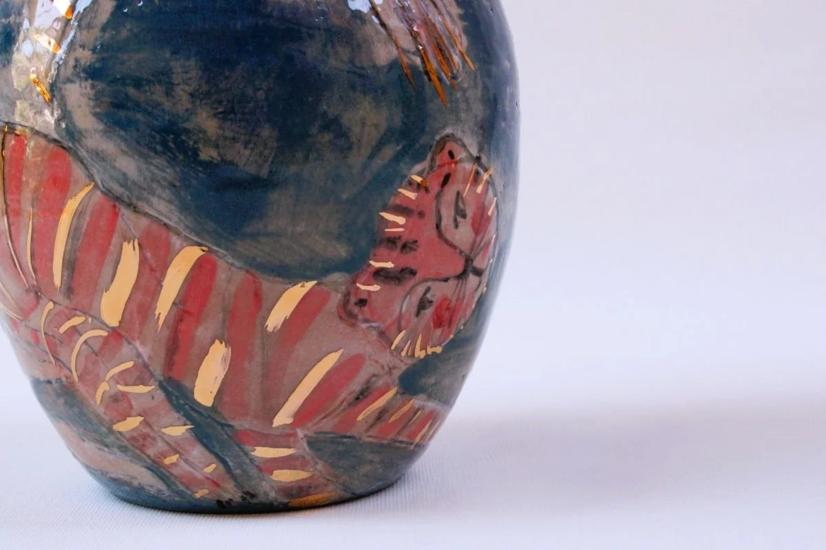 Kunstvolle Keramikvase mit abstraktem Design und leuchtenden Farben auf weißem Hintergrund