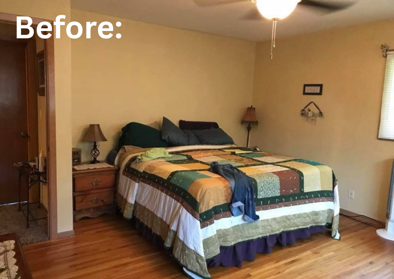 A bedroom with a bed covered with a colorful patchwork quilt, dark pillows, two bedside tables with lamps, and a window with blinds. Showcasing the before photo of repainting this room.
