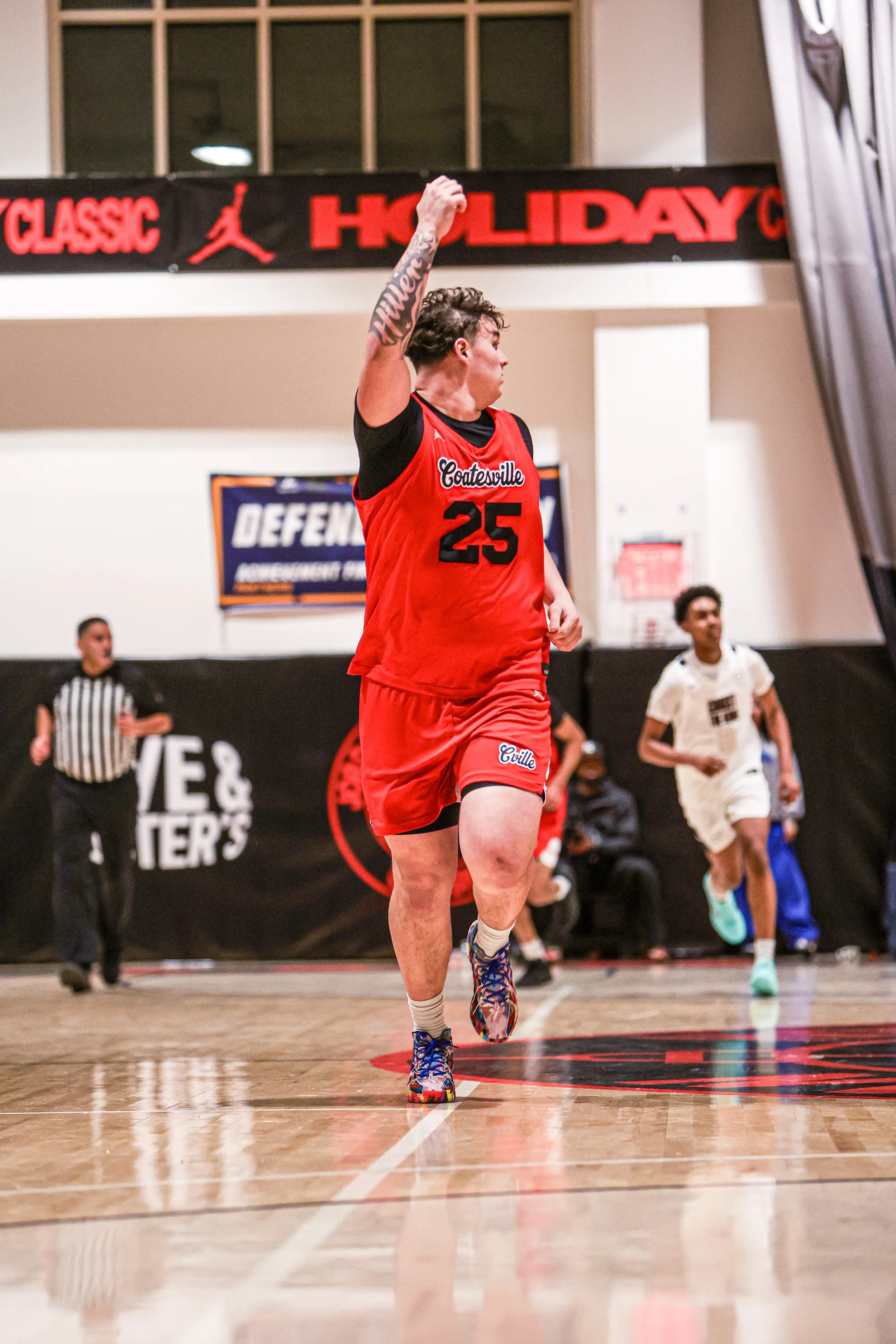 Two high school basketball players competing for a rebound near the basket, with a crowd of spectators in the background.