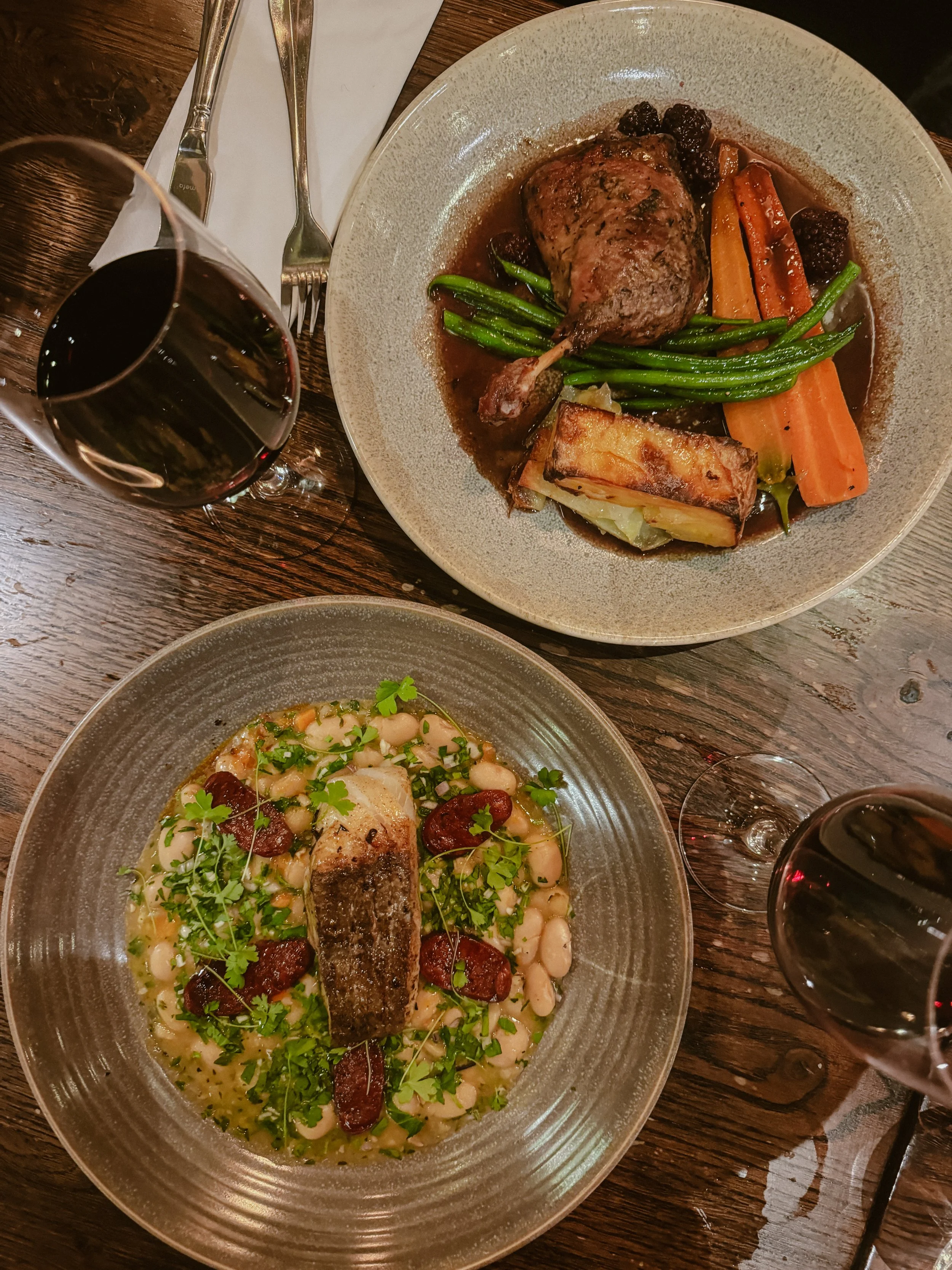 Table with dishes on and glasses of wine 