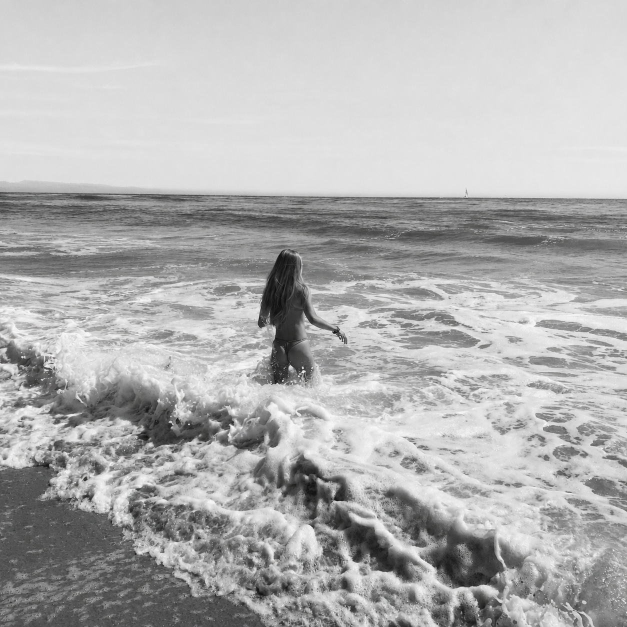 Woman walking along the ocean shoreline, representing confidence, self-care, and personal wellness.
