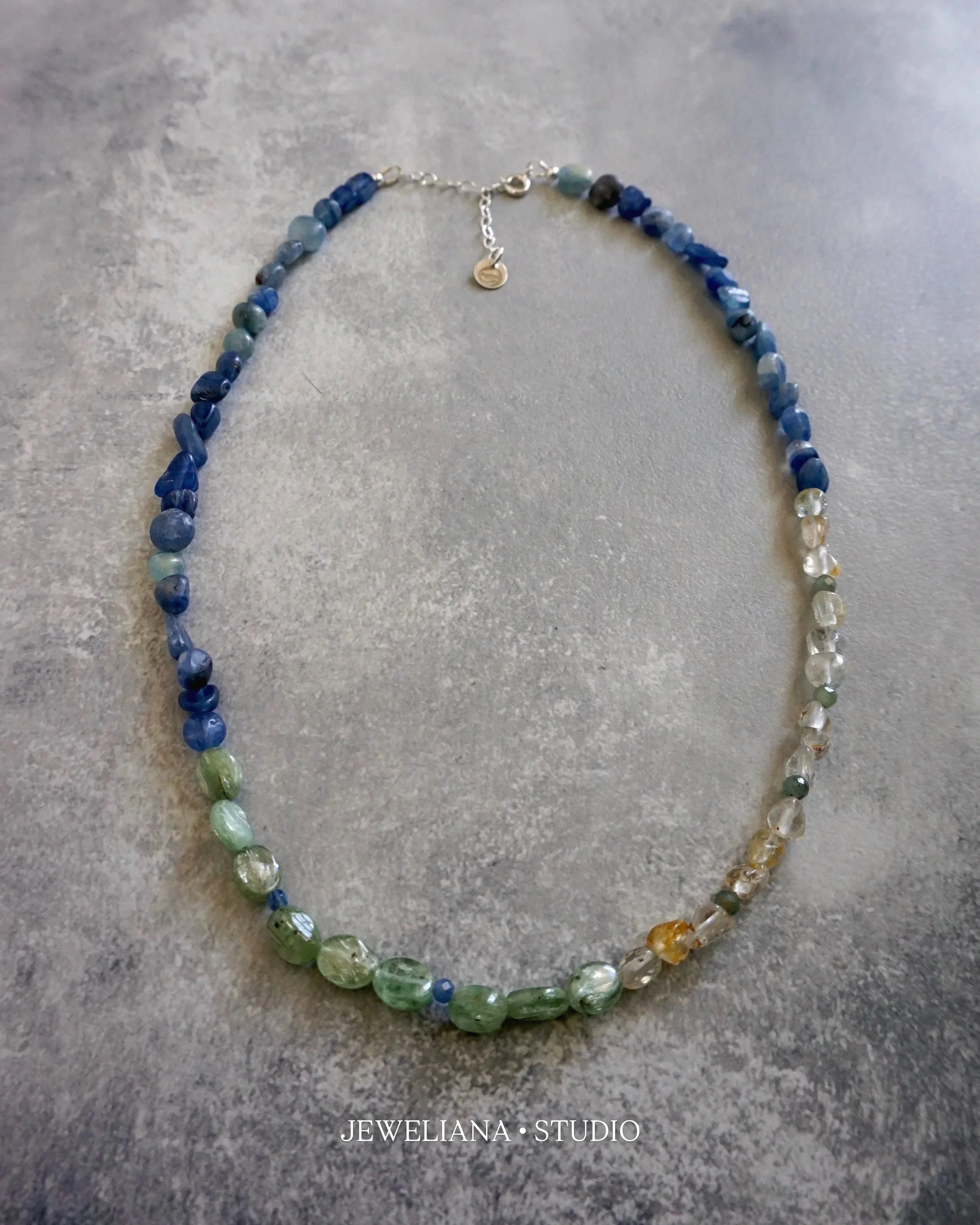 Jeweliana Studio Lake Tahoe chunky kyanite and clear topaz necklace styled over a white sweater and summer linen top