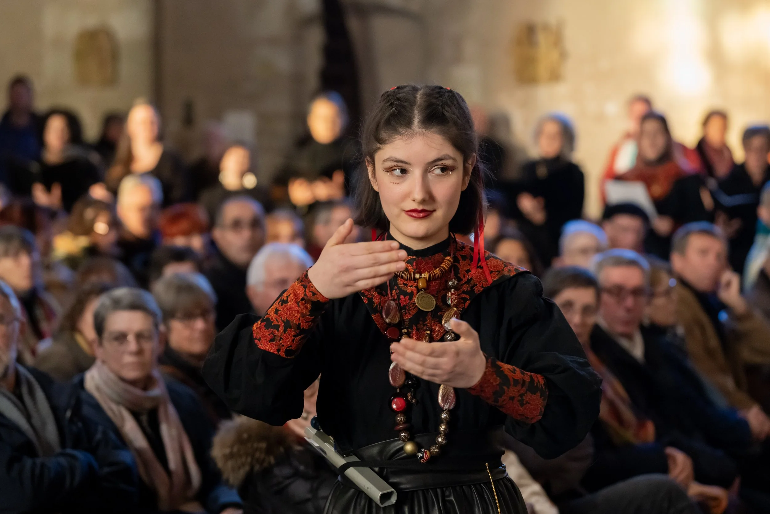 Zana Zaganjori dans sa tenue de concert du choeur Mikrokosmos en train de diriger le choeur en concert.
