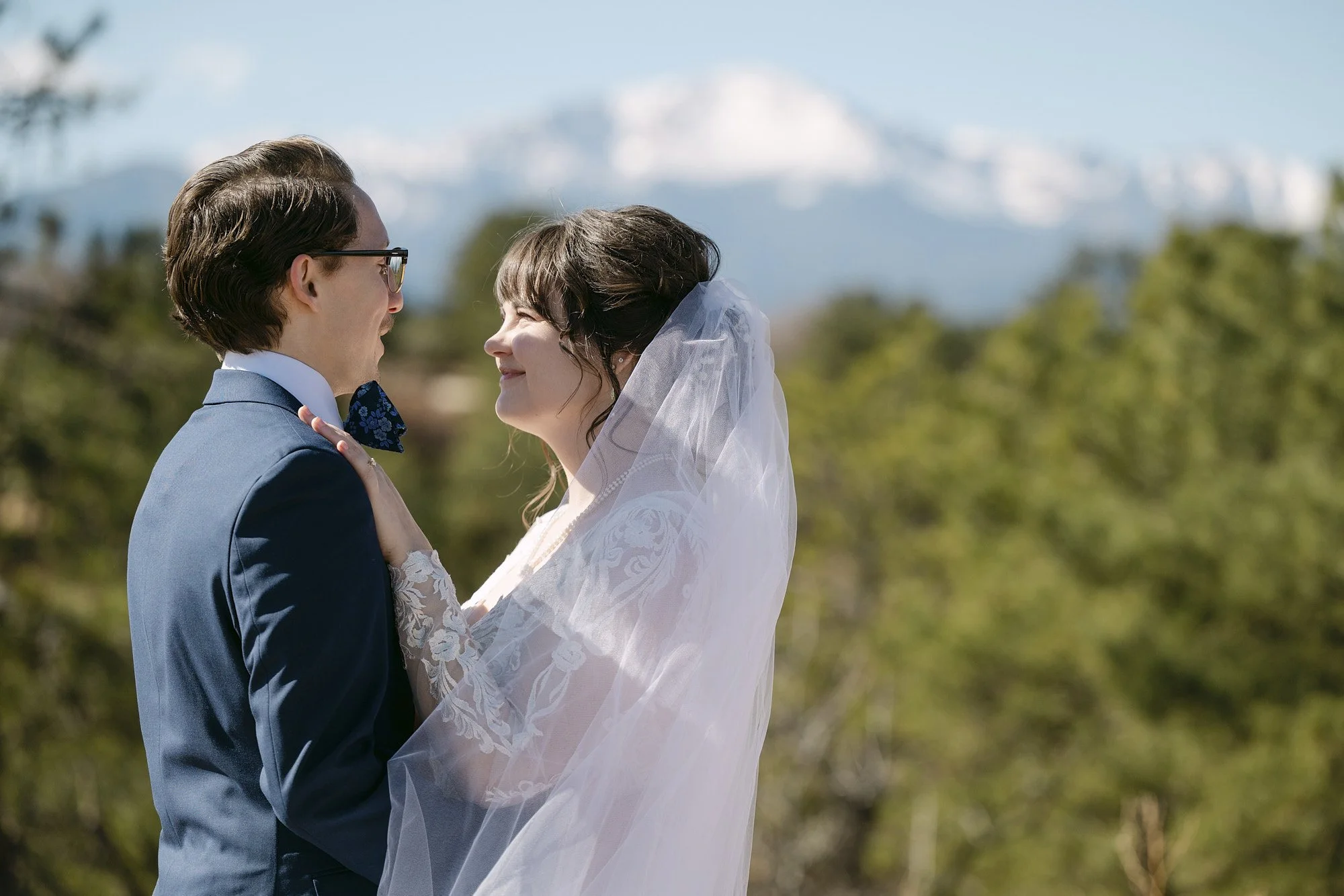 A bride and groom look into each others eyes at Palmer Park in Colorado Springs with a view of Pike's Peak behind them.