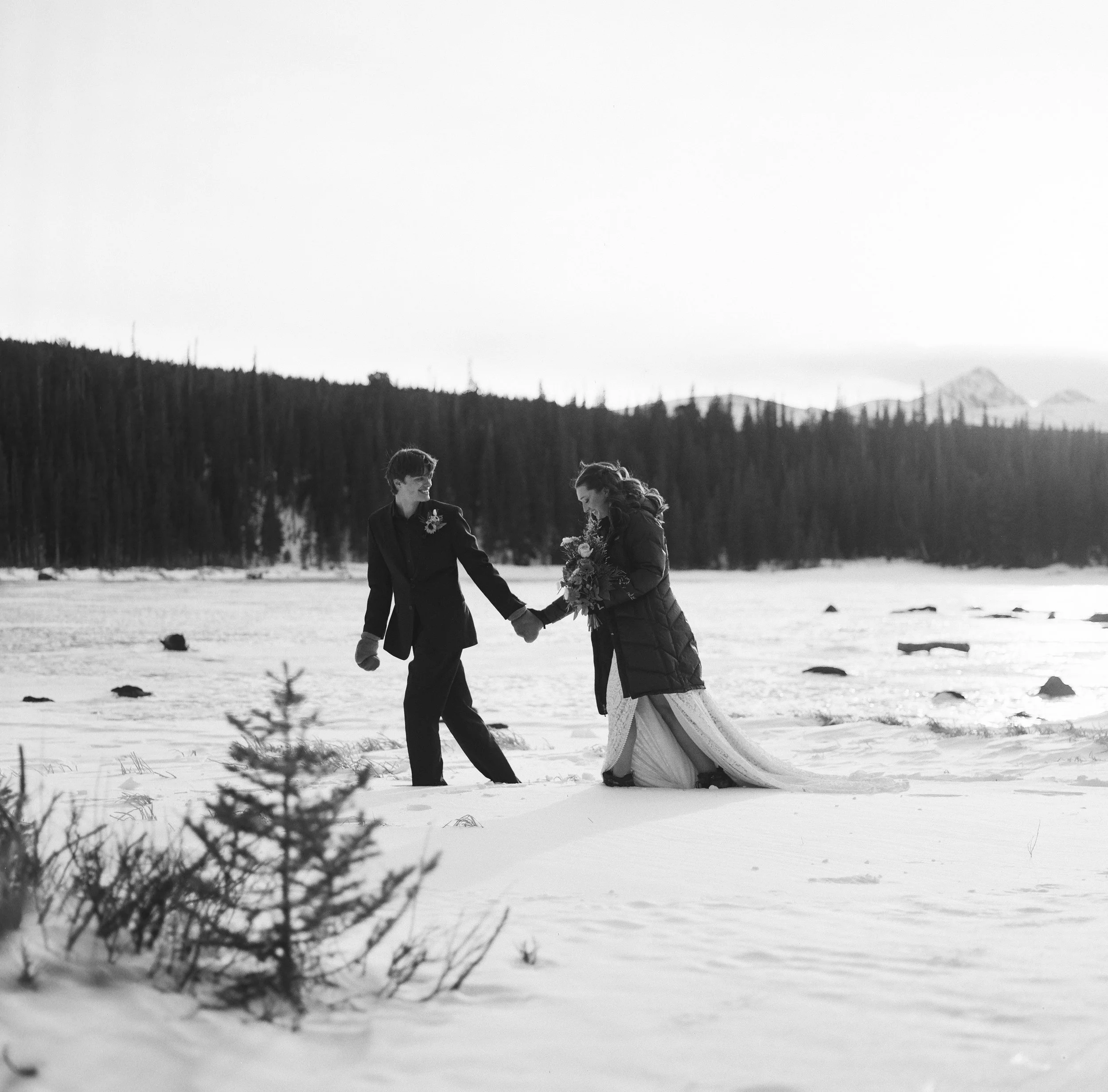 A medium format film scan of a couple walking across a frozen lake in Colorado.