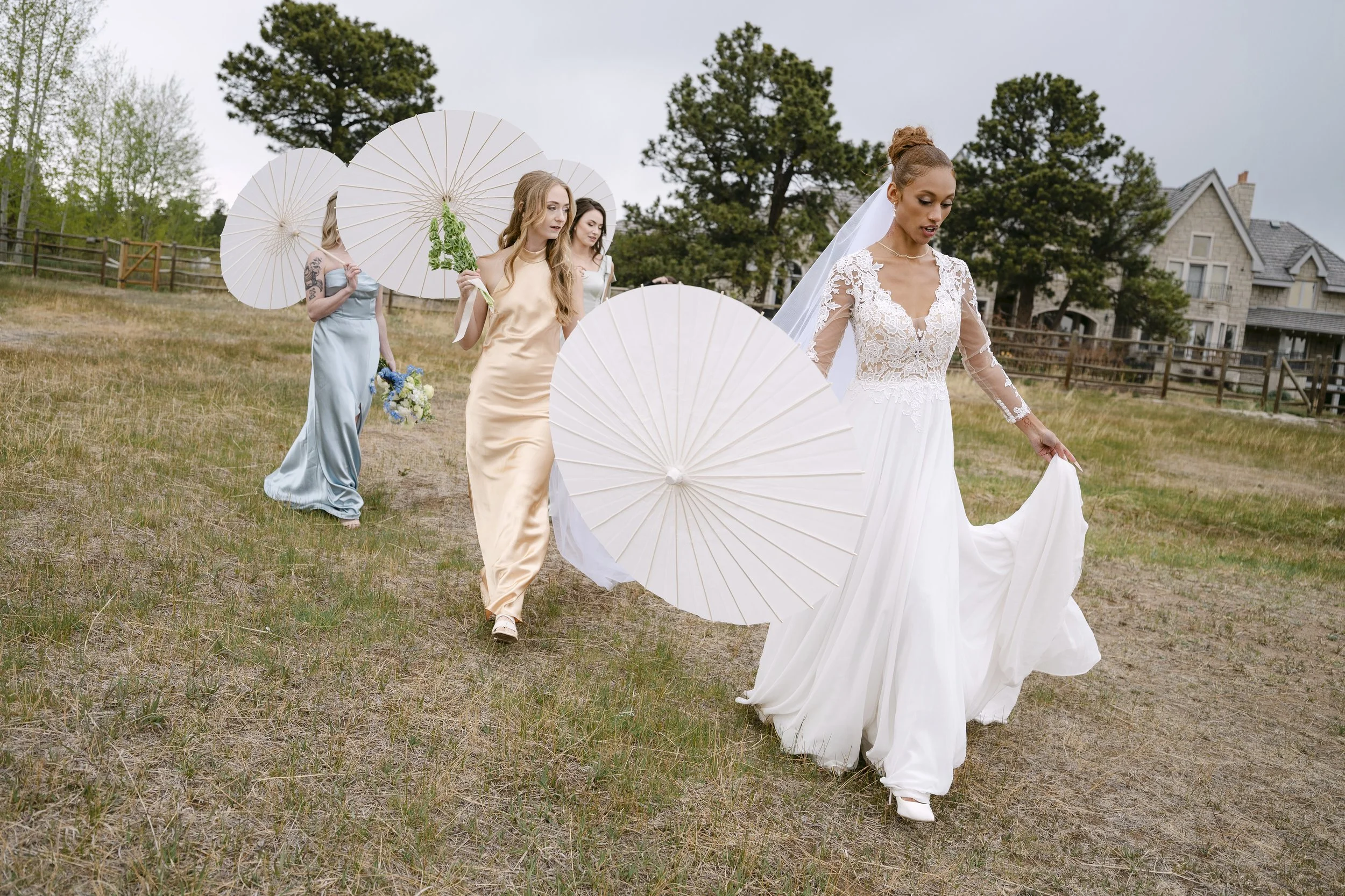 Indya and her bridesmaids walking across the lawn at Greystone Castle in Boulder, Colorado during a spring styled shoot