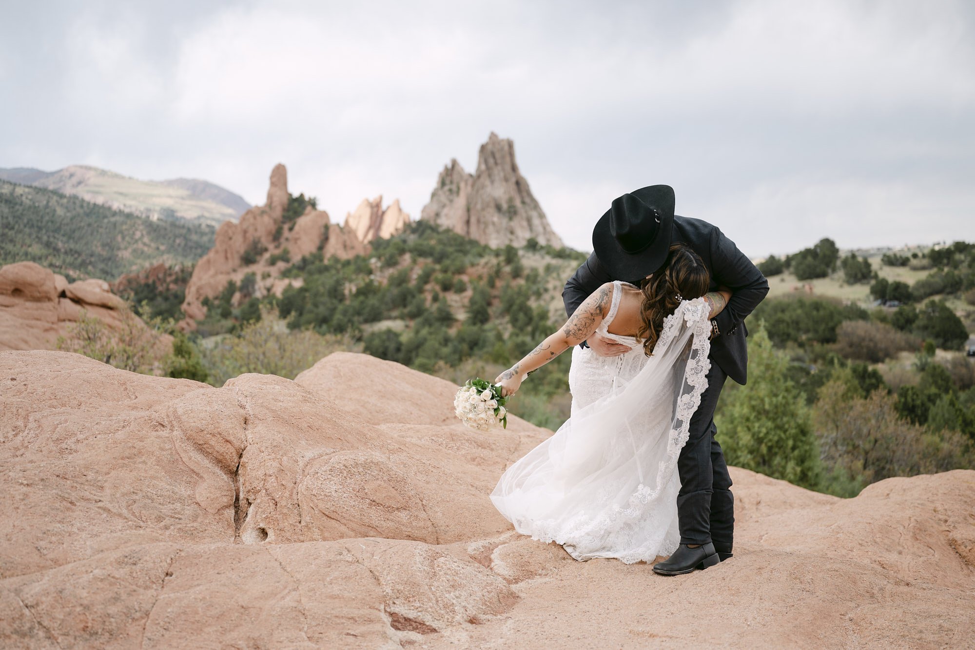 A bride and groom dip kiss in front of the red rock views of Garden of the Gods in Colorado Springs.