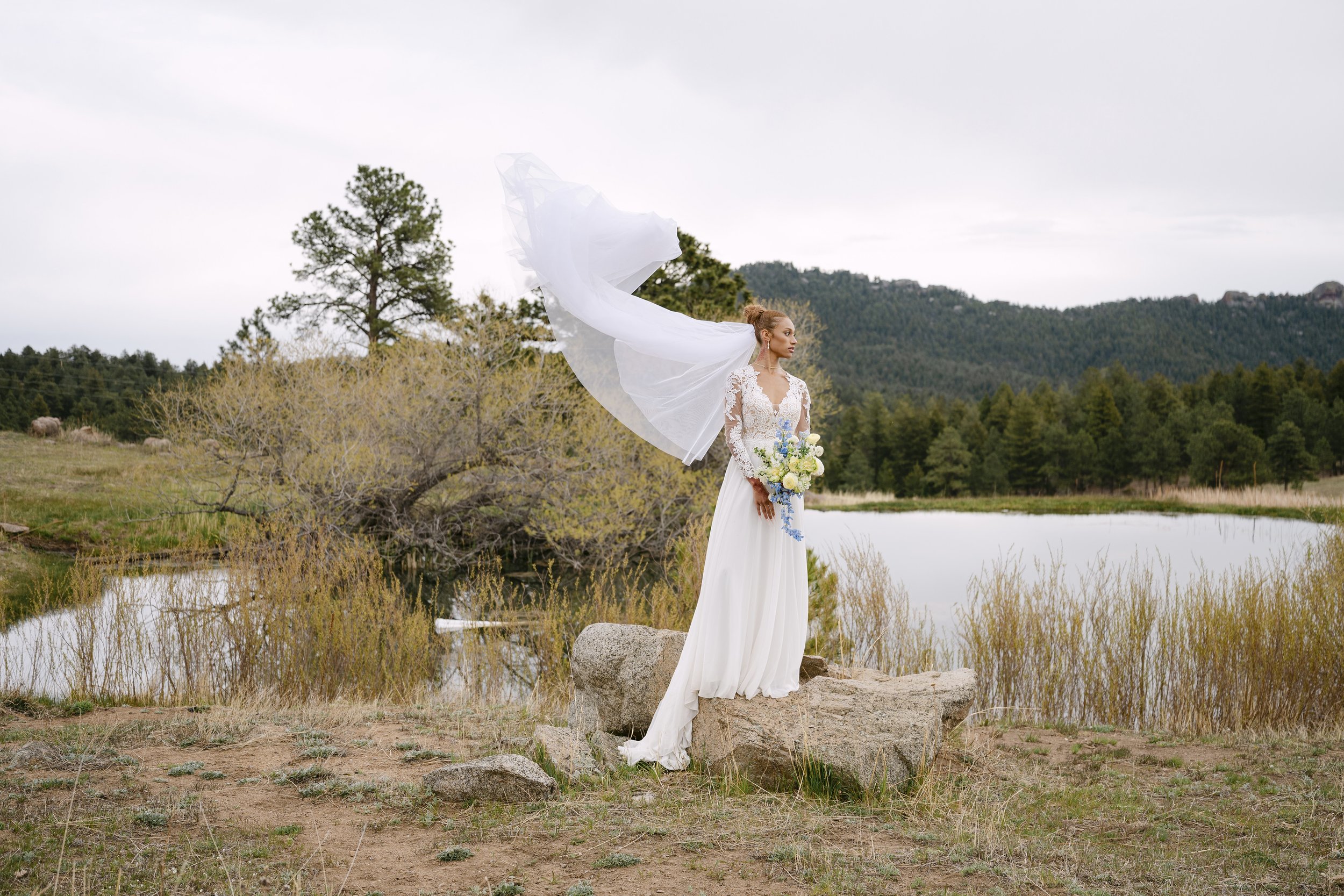The brides vail catches the wind near the pond on the grounds of Greystone Castle on Flagstaff Mountain.