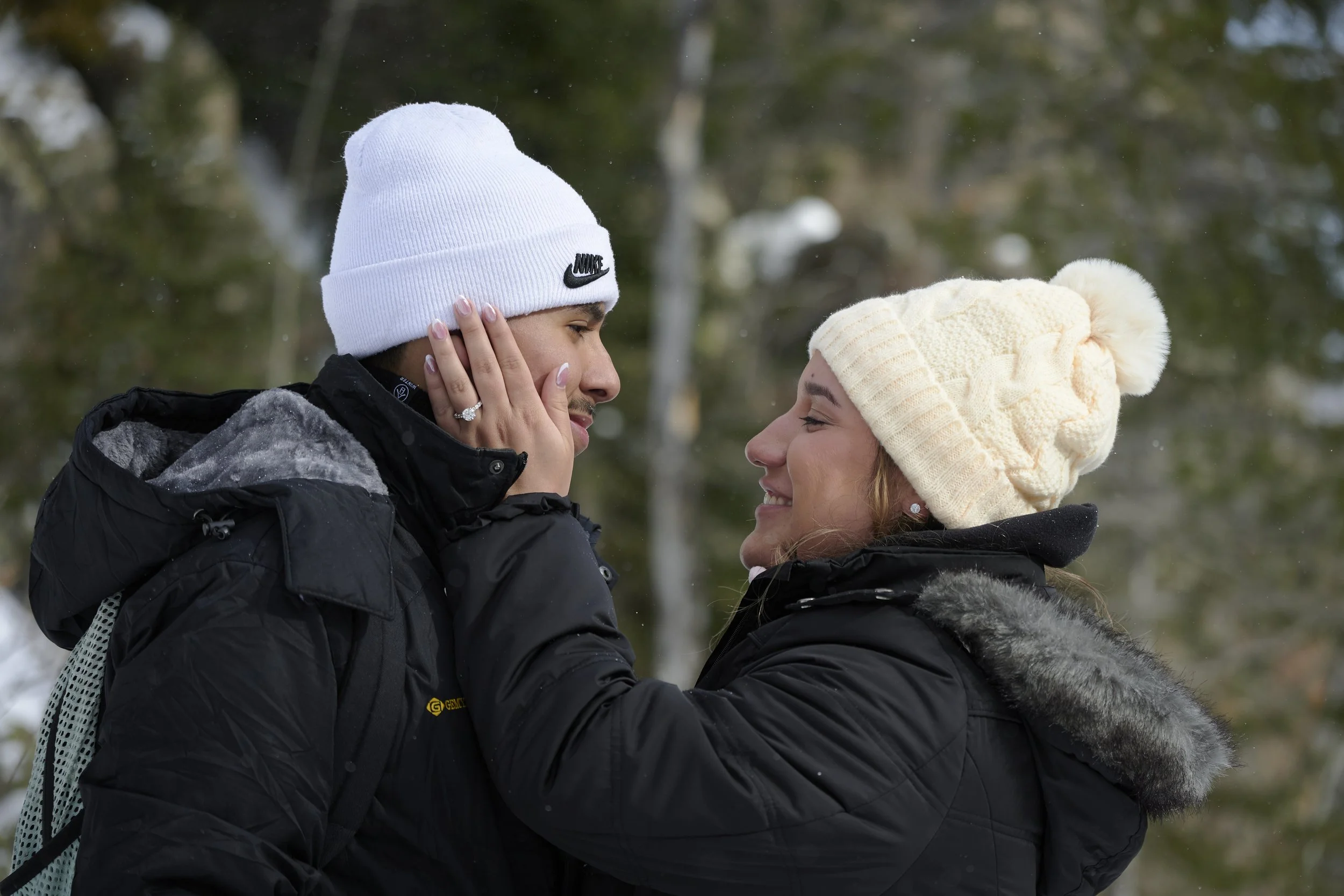 A couple look into each others eyes showing off the new engagement ring in RMNP.