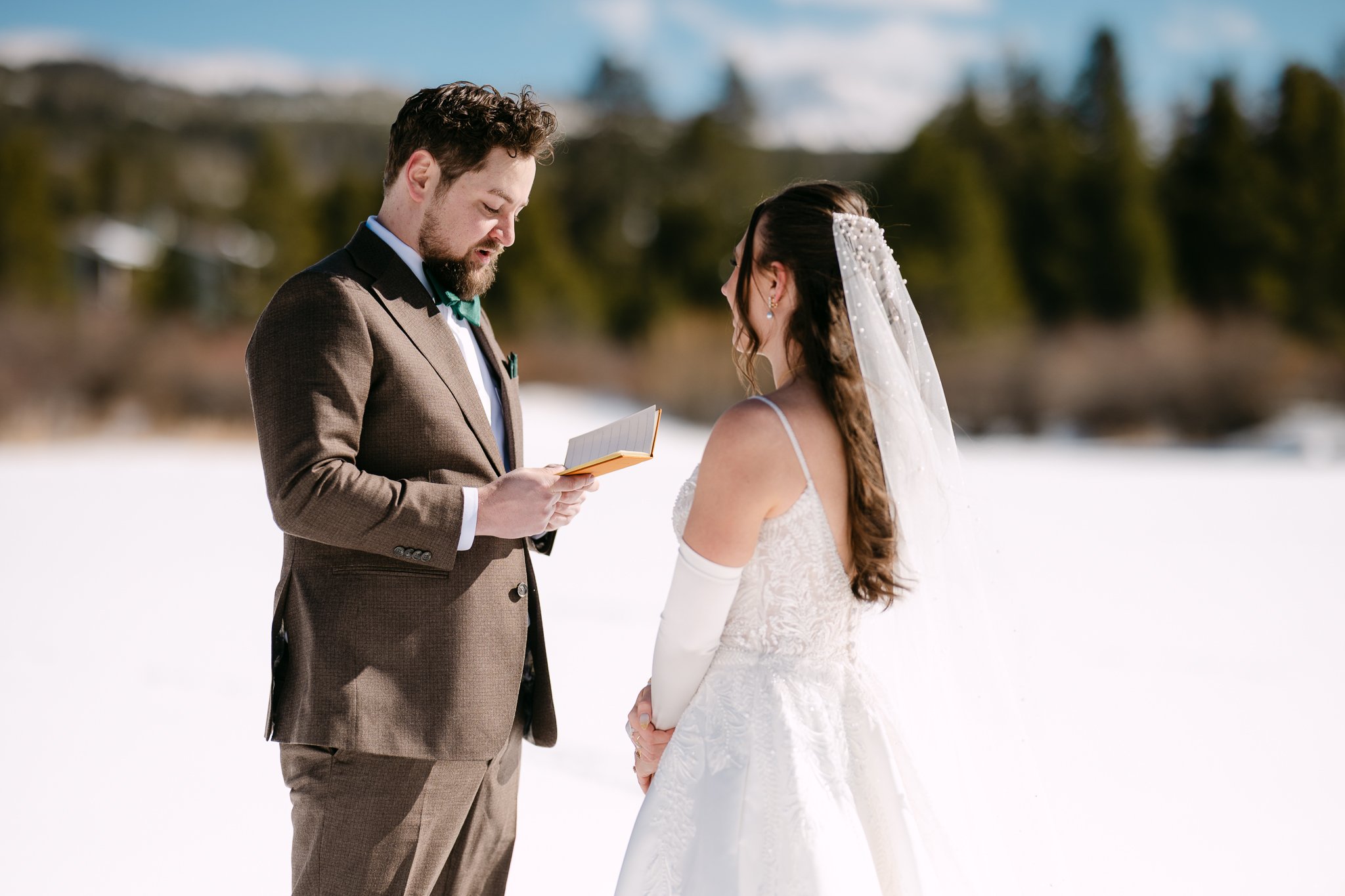 A groom shares his private vows on the frozen lake near their winter park wedding venue