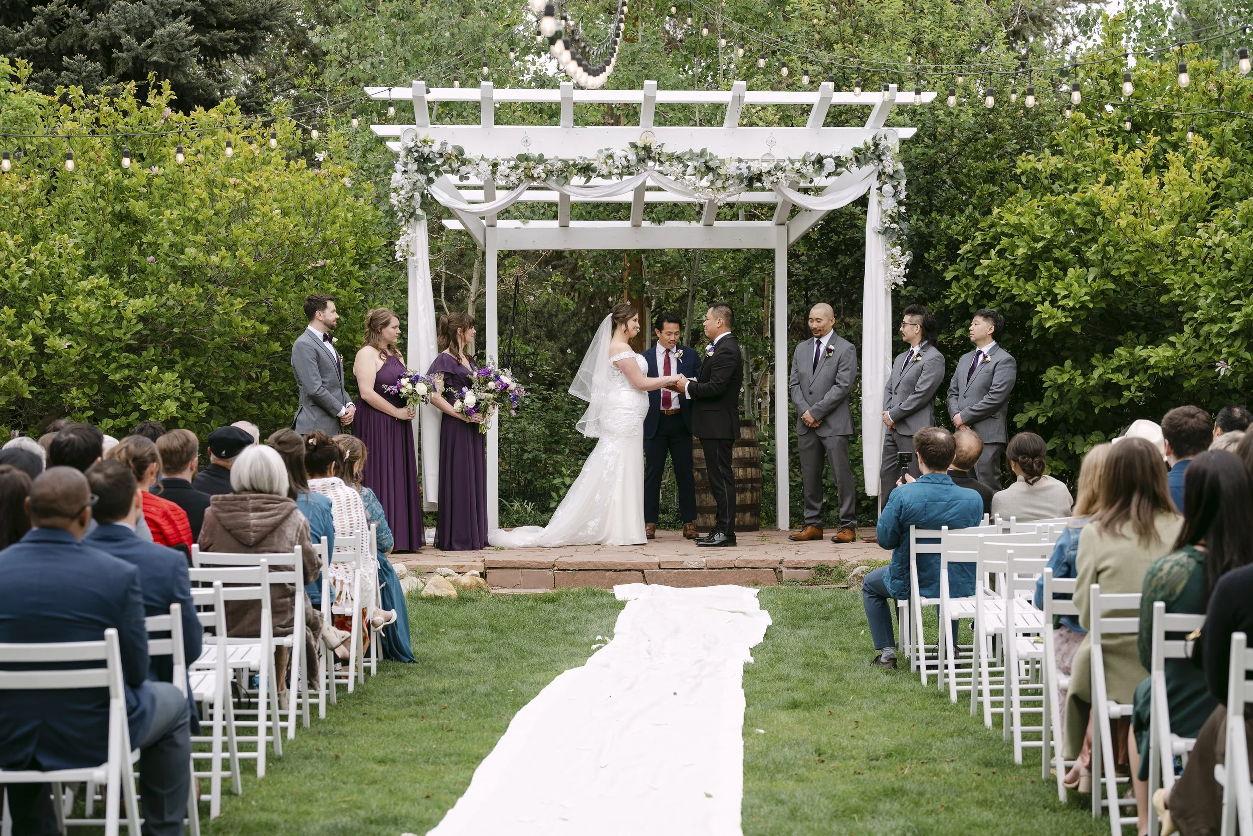 A wedding day mid ceremony at the outdoor ceremony location at church ranch event center in Westminster colorado.