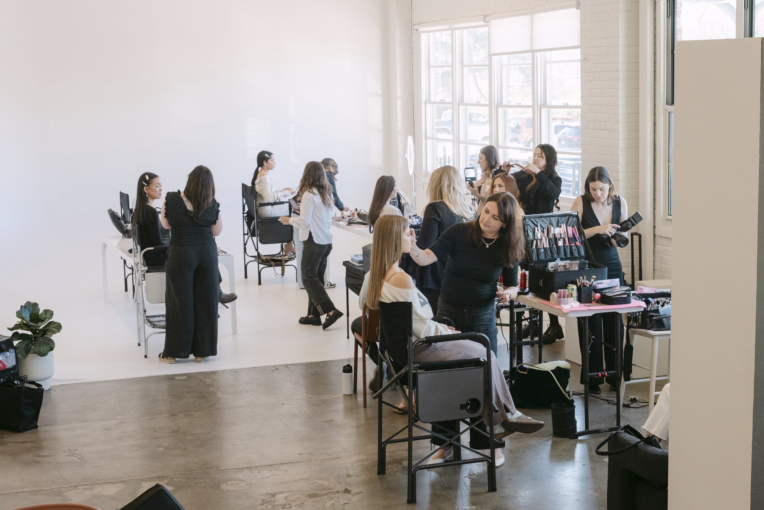 An overview of Sunshine Beauty Bridal artists working on several brides' makeup during the team's spring training workshop at Realm Denver