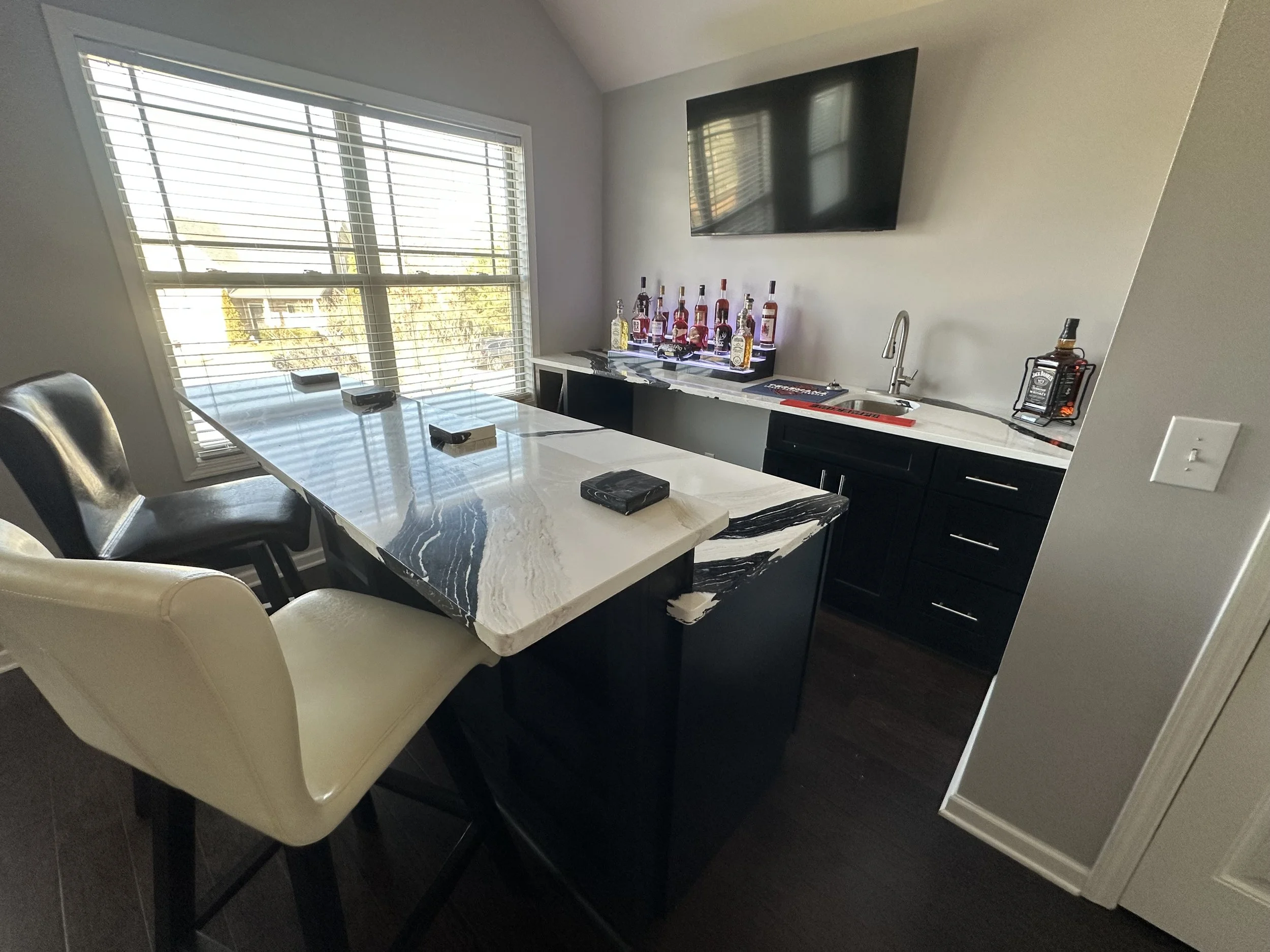 Completed kitchen and home bar remodel showcasing custom cabinetry, waterfall-style countertops, and modern finishes. This renovation by Dangerfield Home Improvement blends functionality and luxury for a bold, contemporary home upgrade.