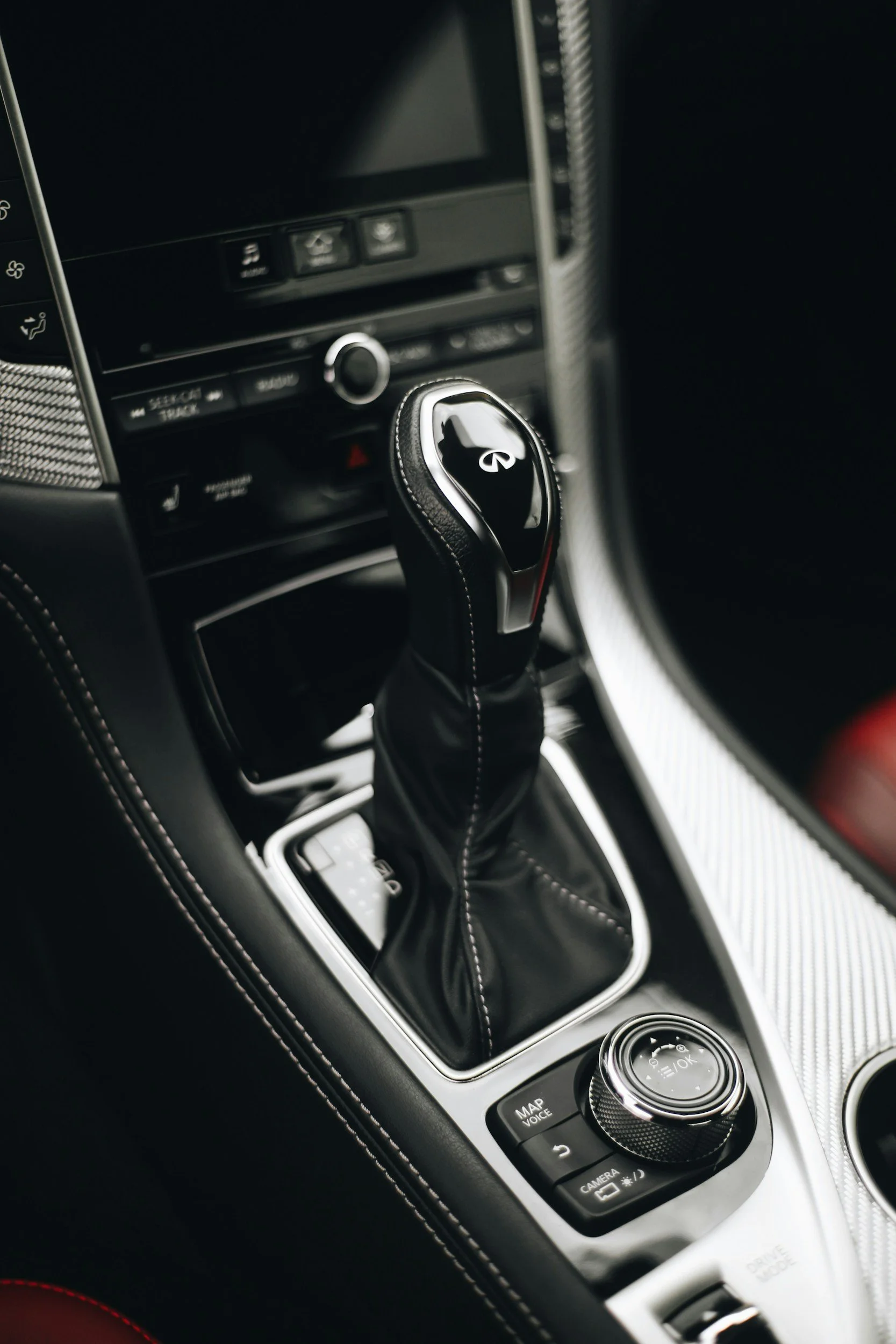 Close-up of a modern car’s gear shift lever surrounded by control buttons on the center console.
