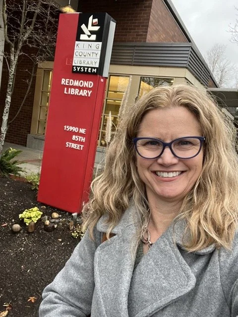 Redmond Literary Arts founder Jenny Lisk in front of the Redmond Library