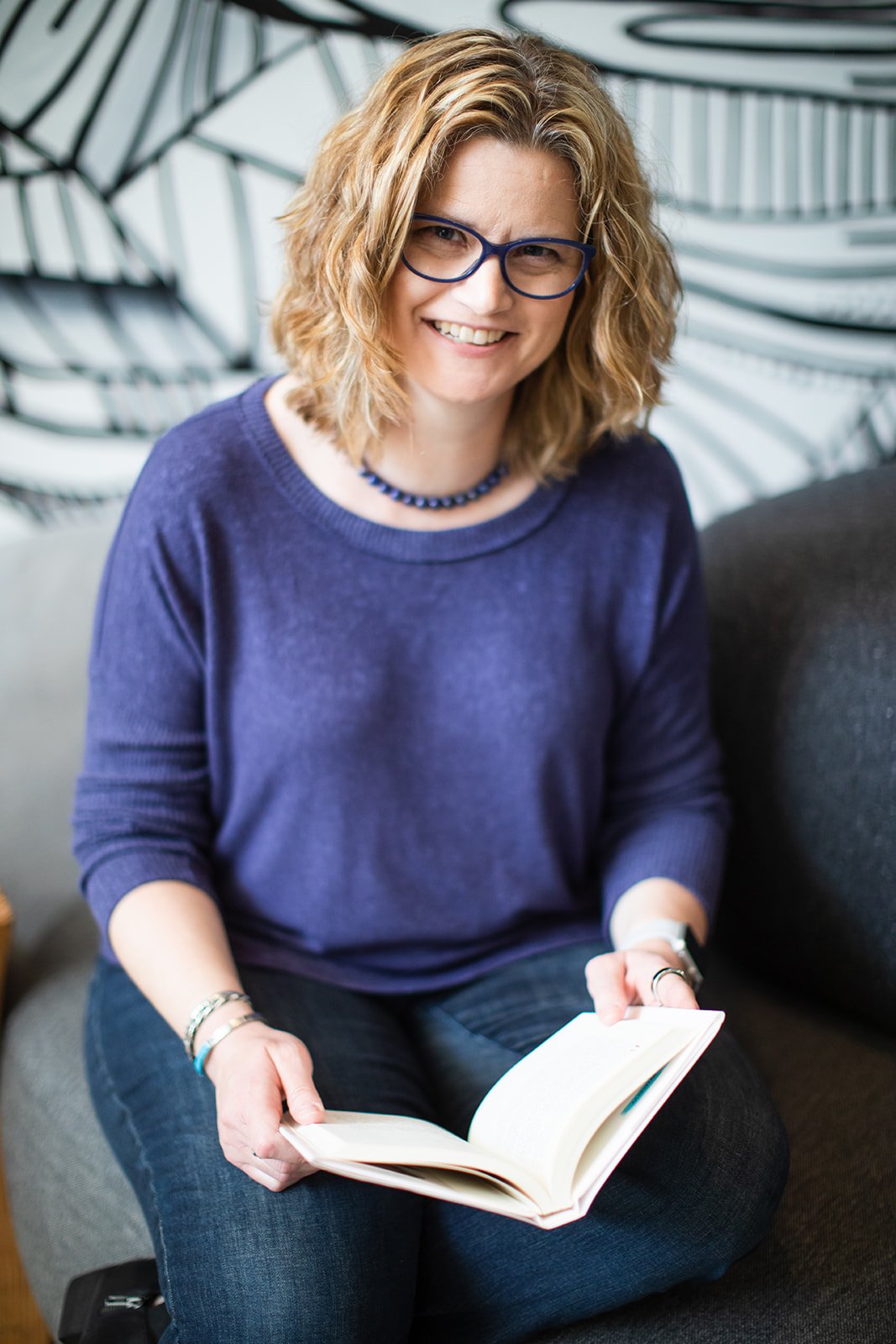 Jenny Lisk photo - purple sweater, holding book