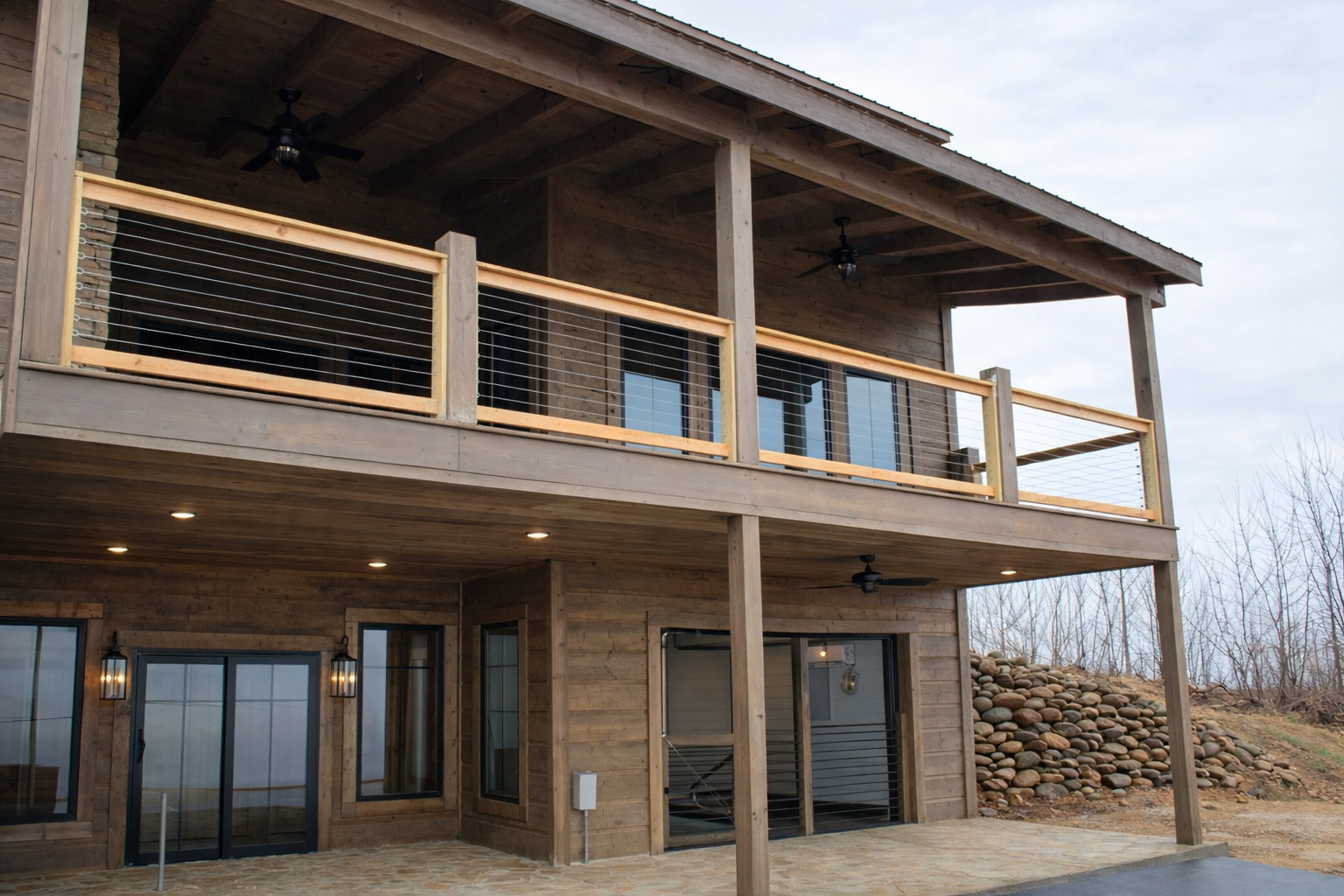 Wood post cable railing system featured on a multi-level mountain cabin exterior deck.