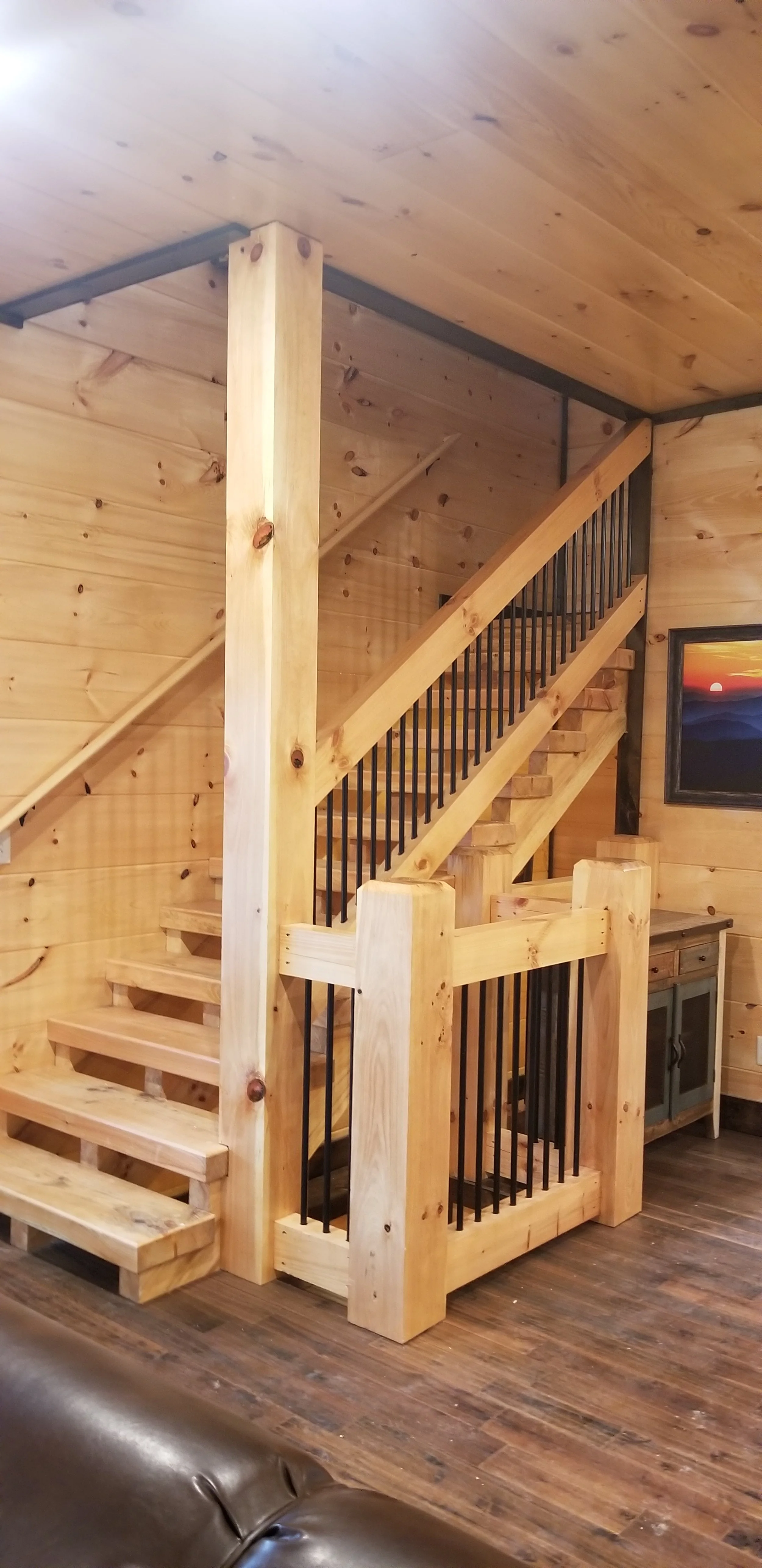 ustic cabin loft overlook with sleek metal railing and exposed wood beams.