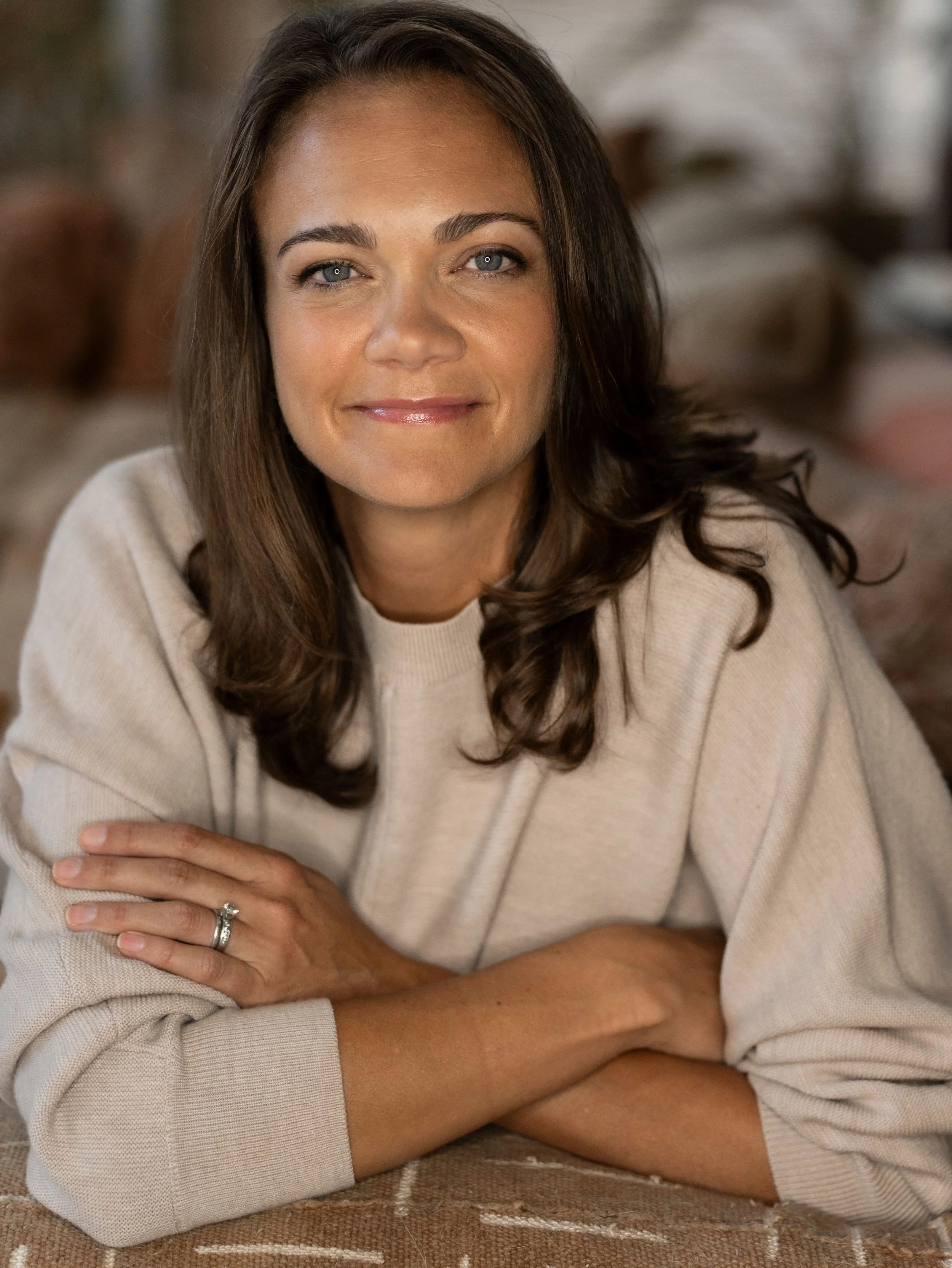 A woman sitting at a table with her arms crossed. Danielle Keenan-Miller, PhD