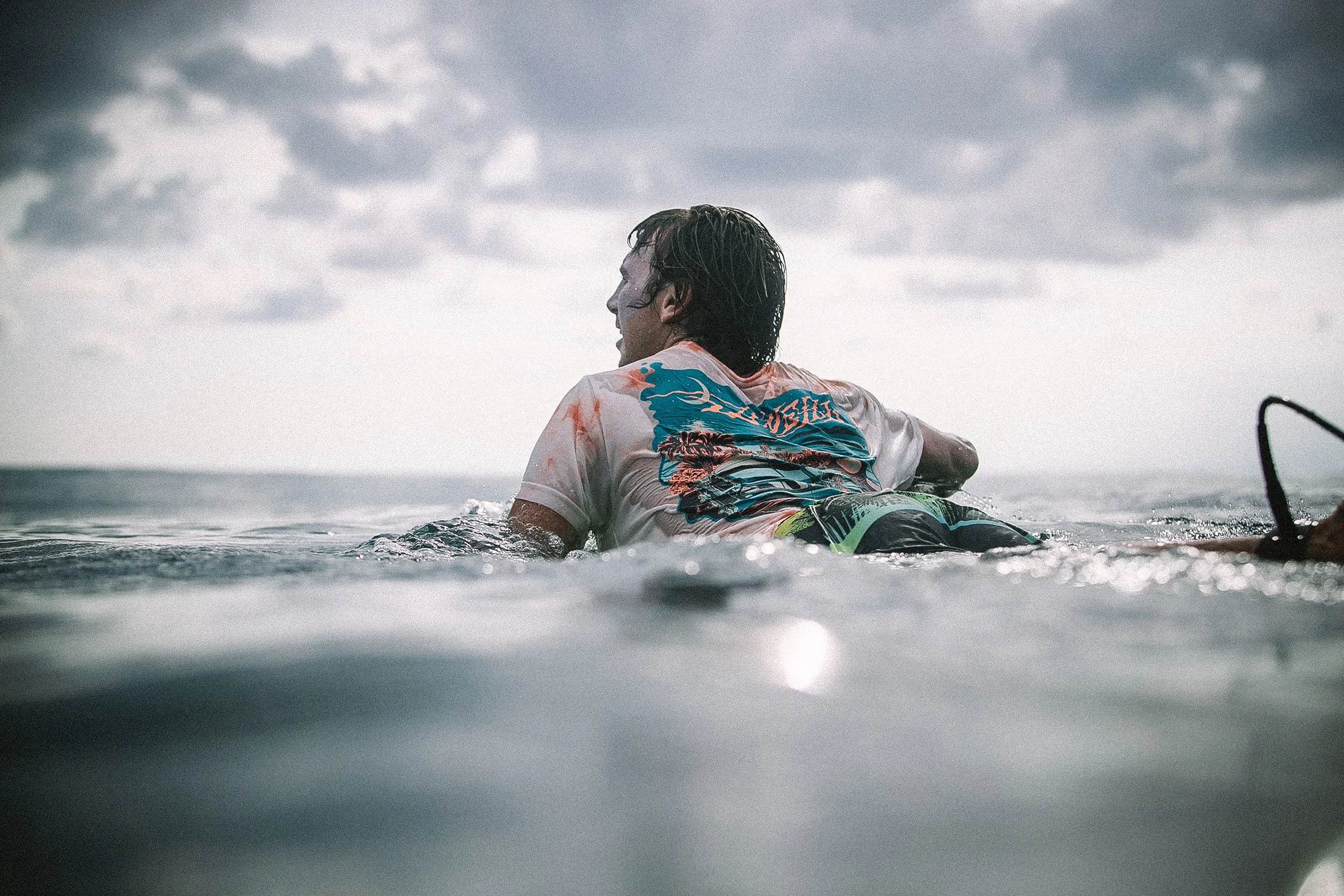 Person swimming in open water during cloudy weather.