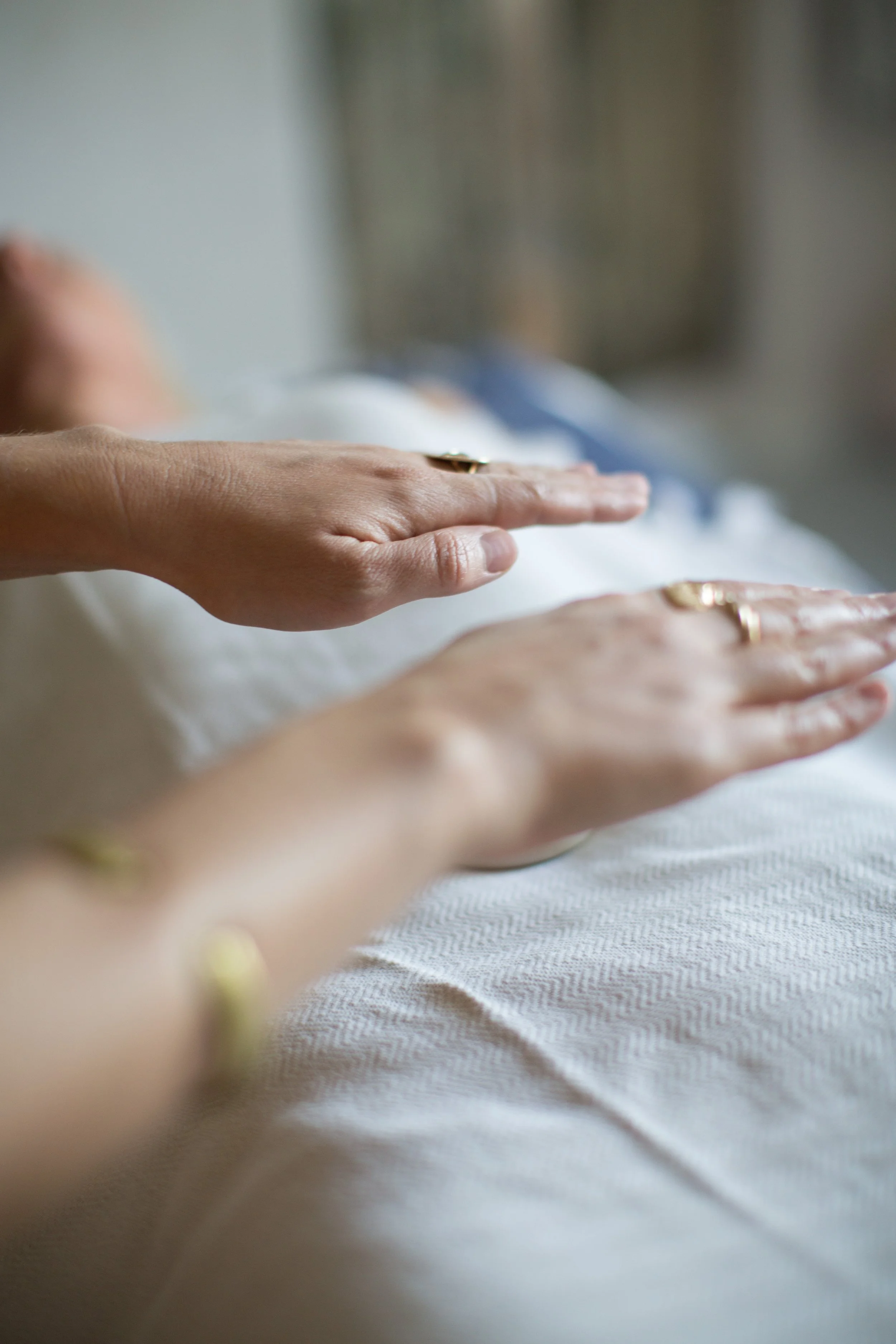 A Reiki healer's hands over over a client while giving healing.