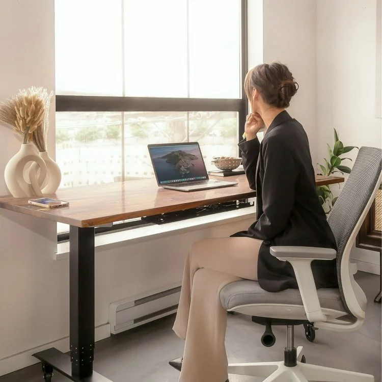 Woman sitting in front of a laptop at a desk.