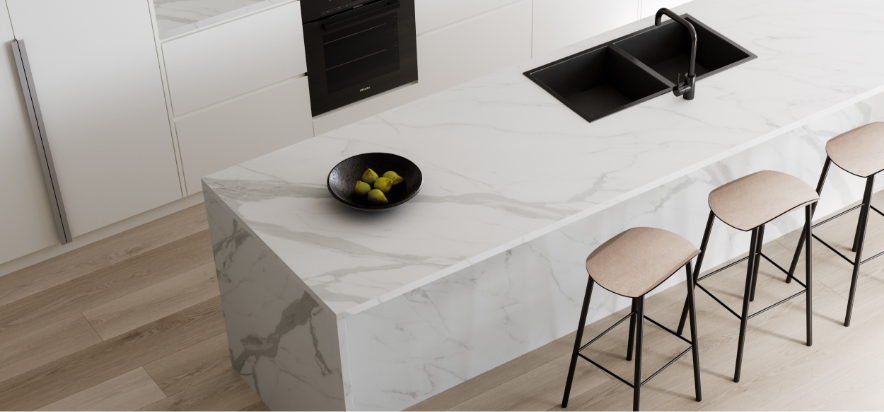 Modern kitchen island with white Laminex countertop, black sink, and three beige stools.