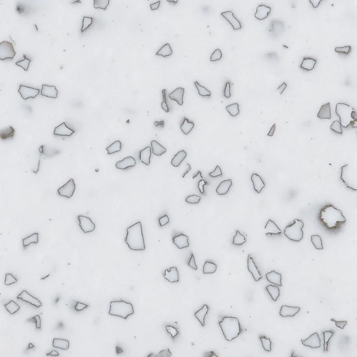 A close-up of a white Staron Mosaic Dalmatian surface with small, irregular black and grey fragments
