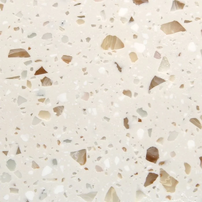 A beige terrazzo benchtop material with white, grey, brown and taupe terrazzo specks. Staron Terrazzo Bologna Solid Surface