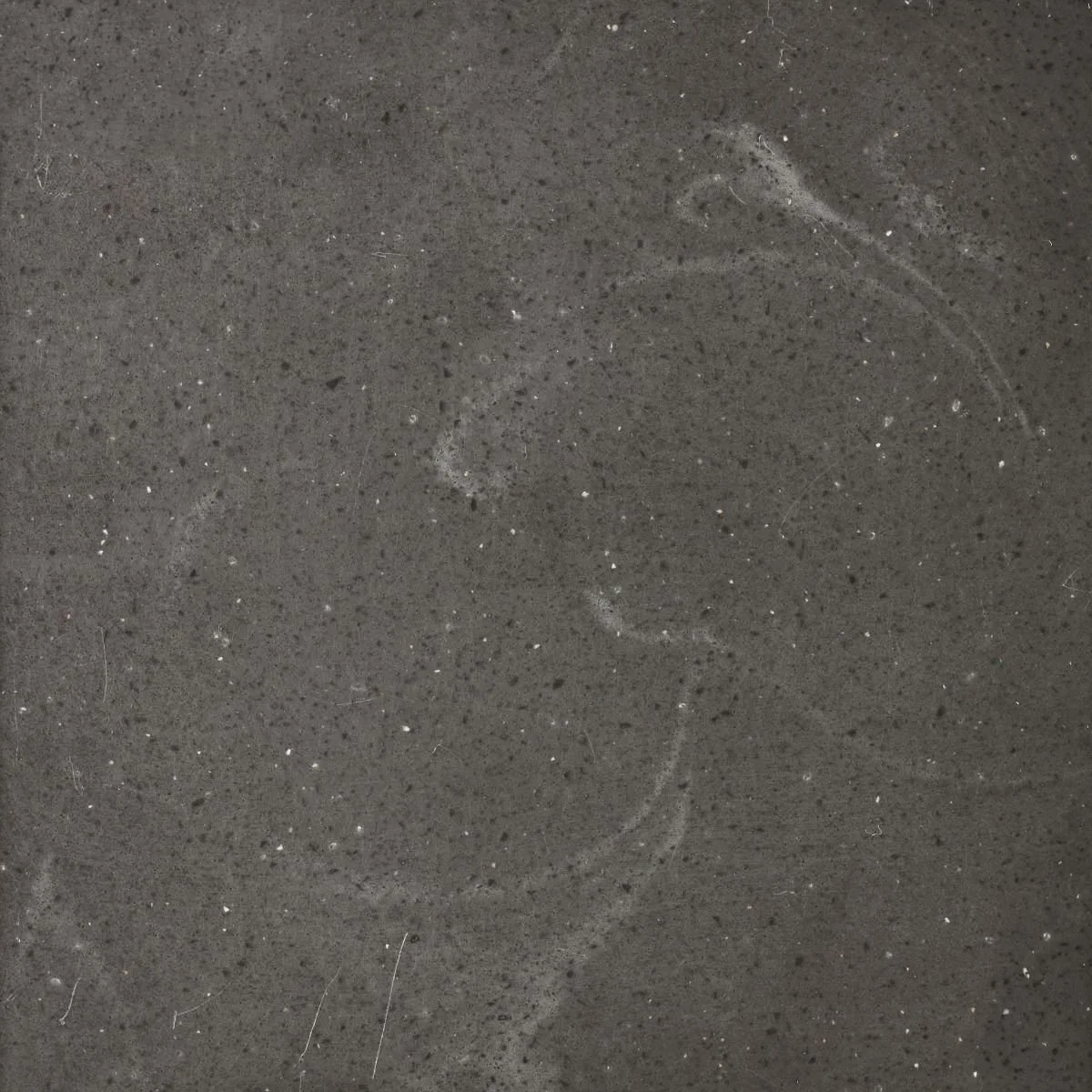 A charcoal benchtop material with soft white veins and white and black specks. Meganite Charcoal Concrete