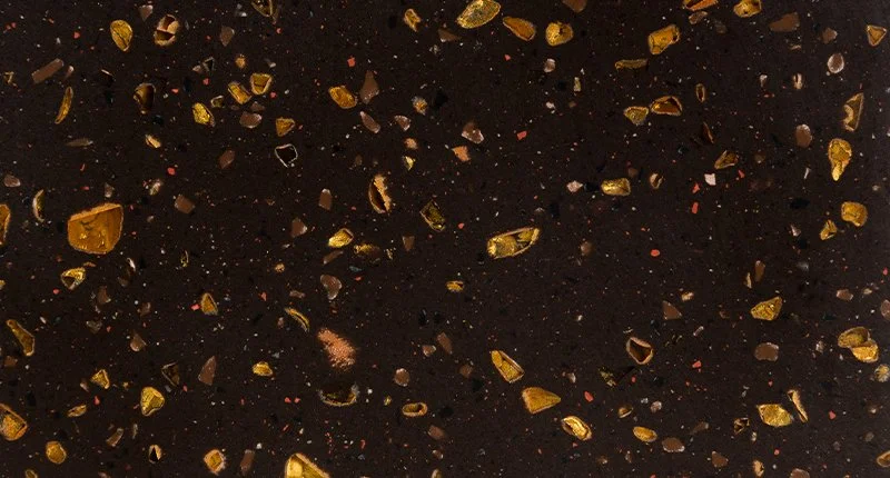 A deep brown benchtop material with sparkling gold aggregate like flecks. Meganite Solar Eclipse