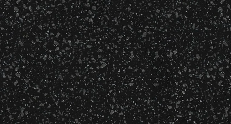 A black benchtop material with dark grey and white aggregate like flecks. Meganite Dark Raven Boulder