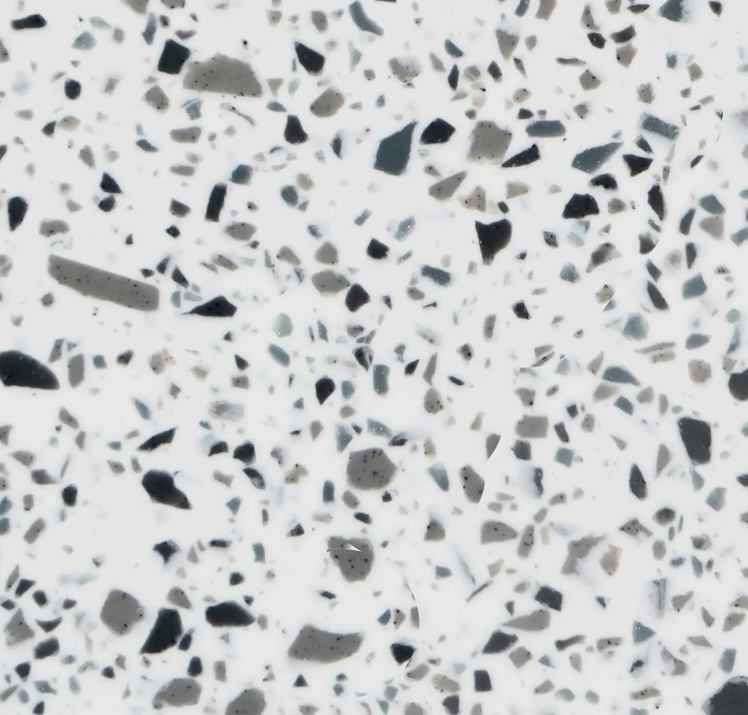 A white based terrazzo benchtop material with dark grey, black and sapphire specks. Megnaite alpi terrazzo