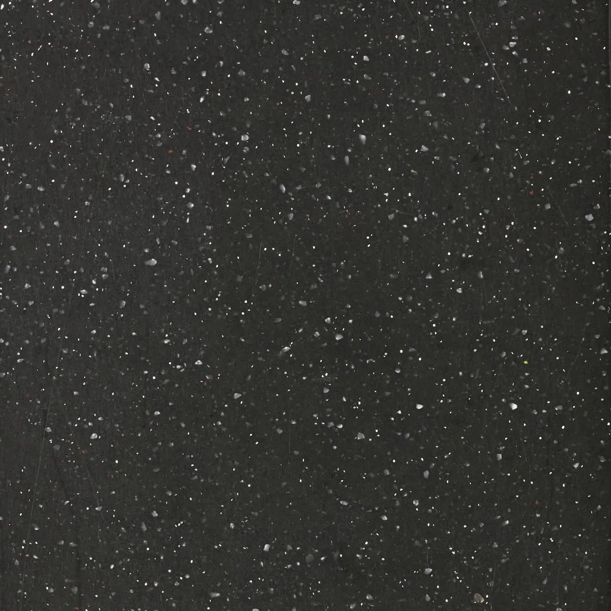 A black benchtop material with white, grey and black terrazzo flecks. Meganite Dark Starry Night.