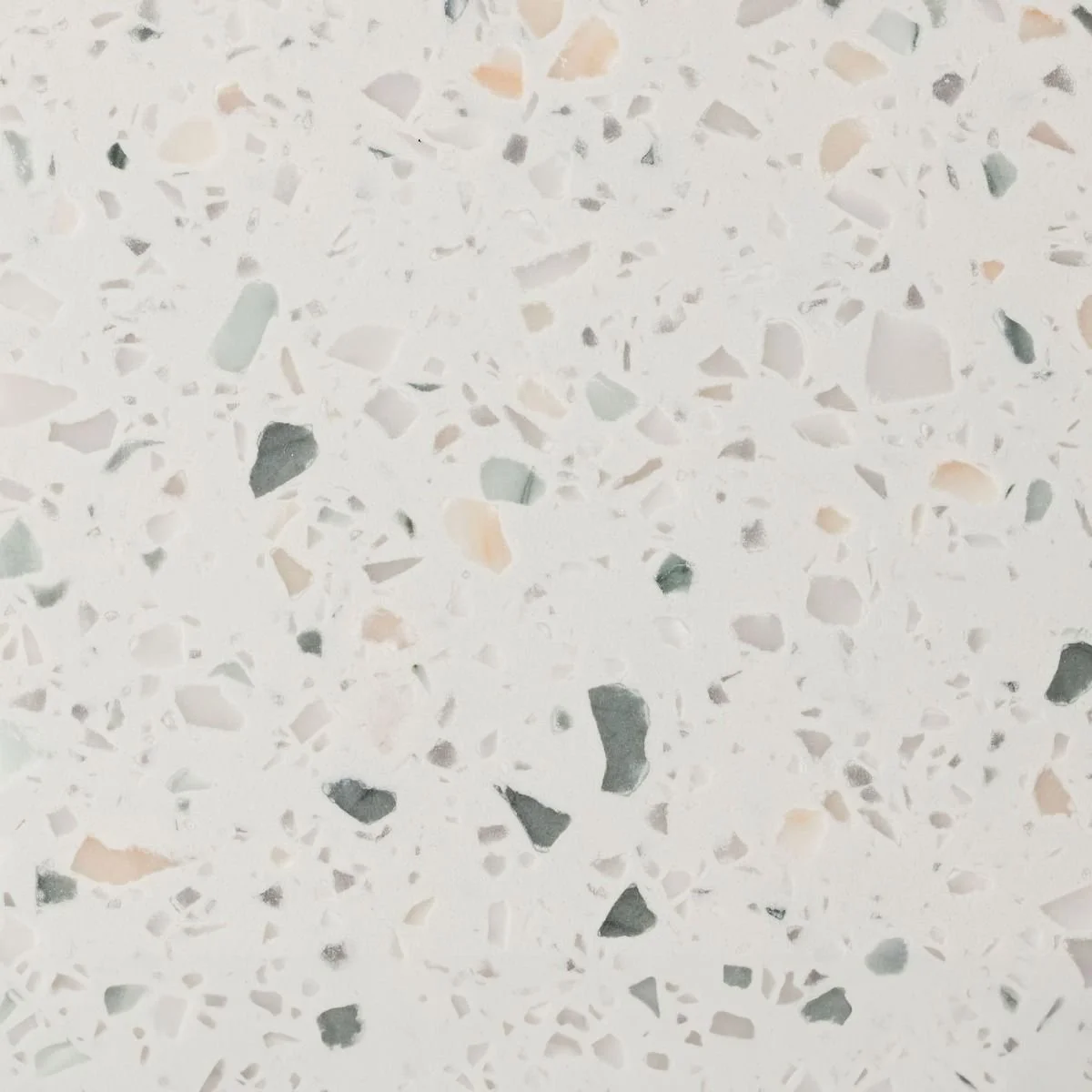 A beautiful benchtop terrazzo material with sage green, peach, white and light blue flecks throughout. Meganite Verde Terrazzo Solid Surface.