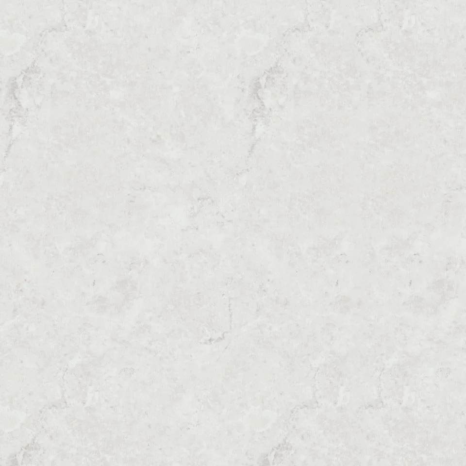 A plain, light-colored wall with subtle texture and some faint darker patches.