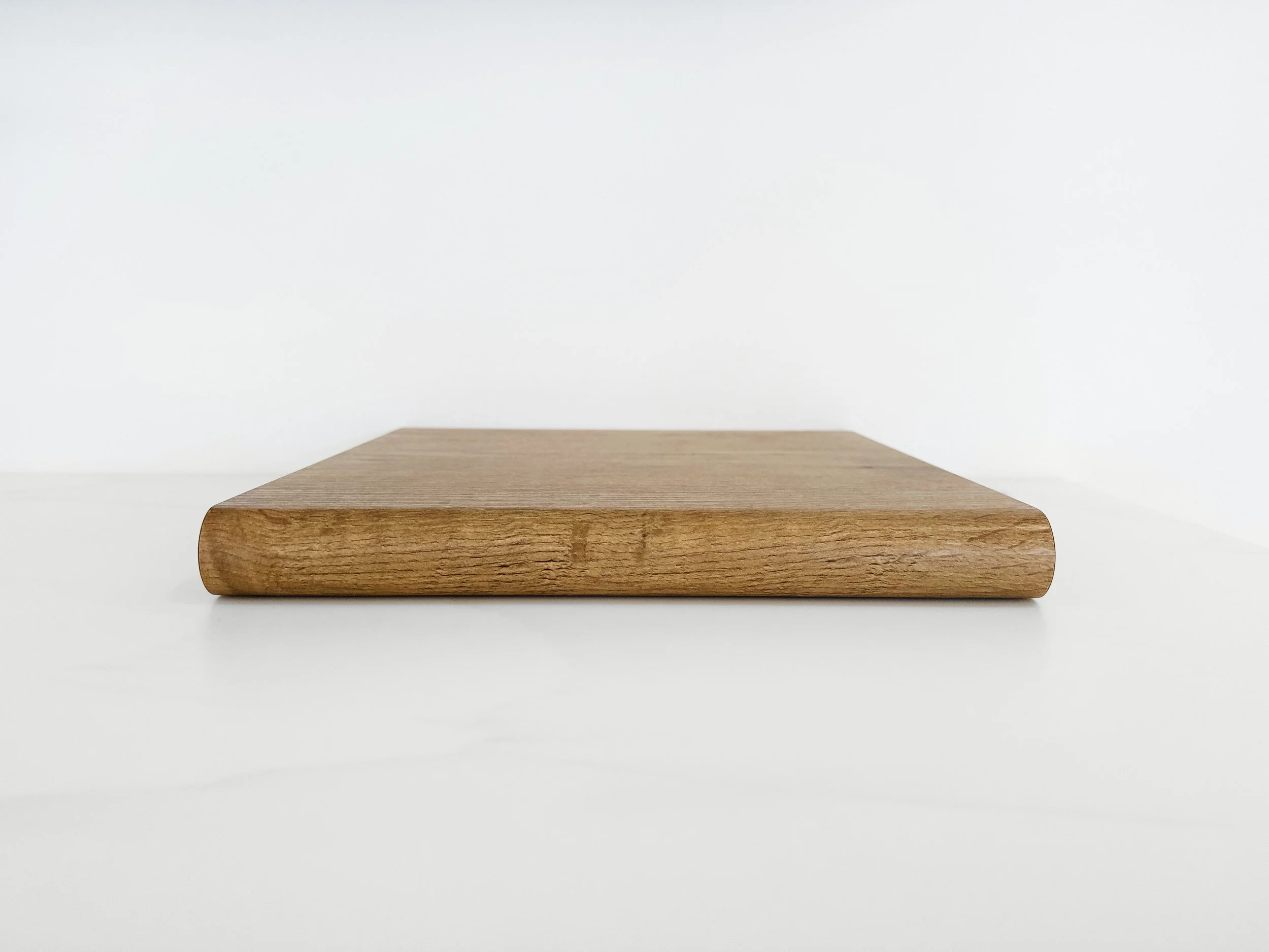 A timber laminate sample showcasing a bullnose edge profile